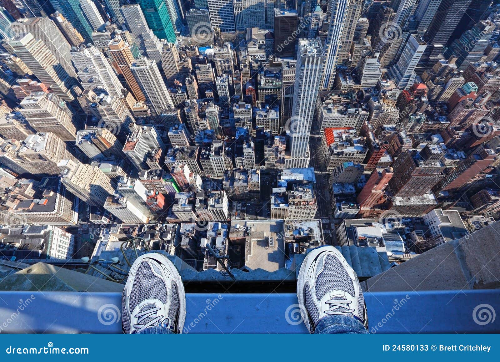 feet on the edge of tall building