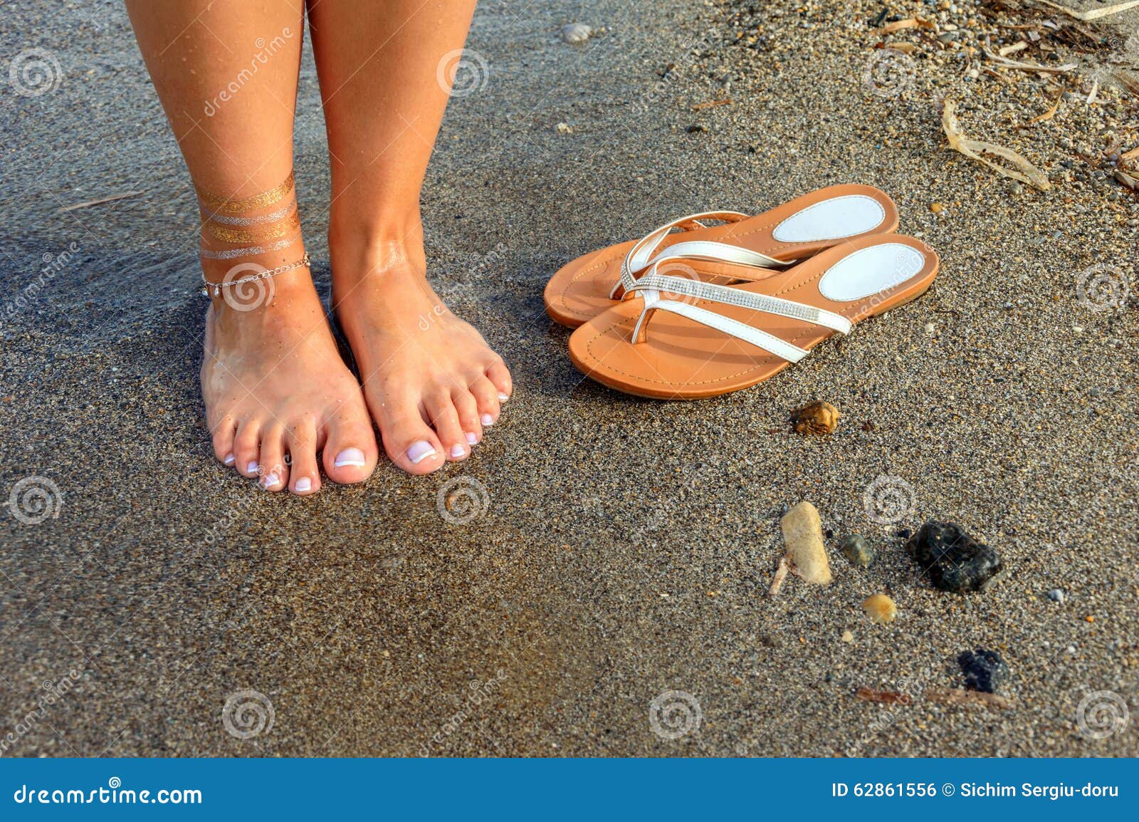 Feet And Flip Flops On The Beach Stock Photo - Image: 62861556