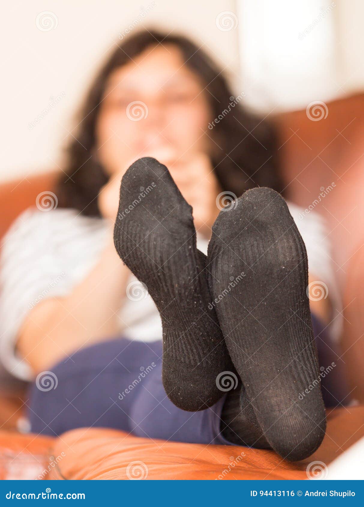 Close up of woman female feet in pink socks on a bed in bedroom relaxing in  the evening Stock Photo