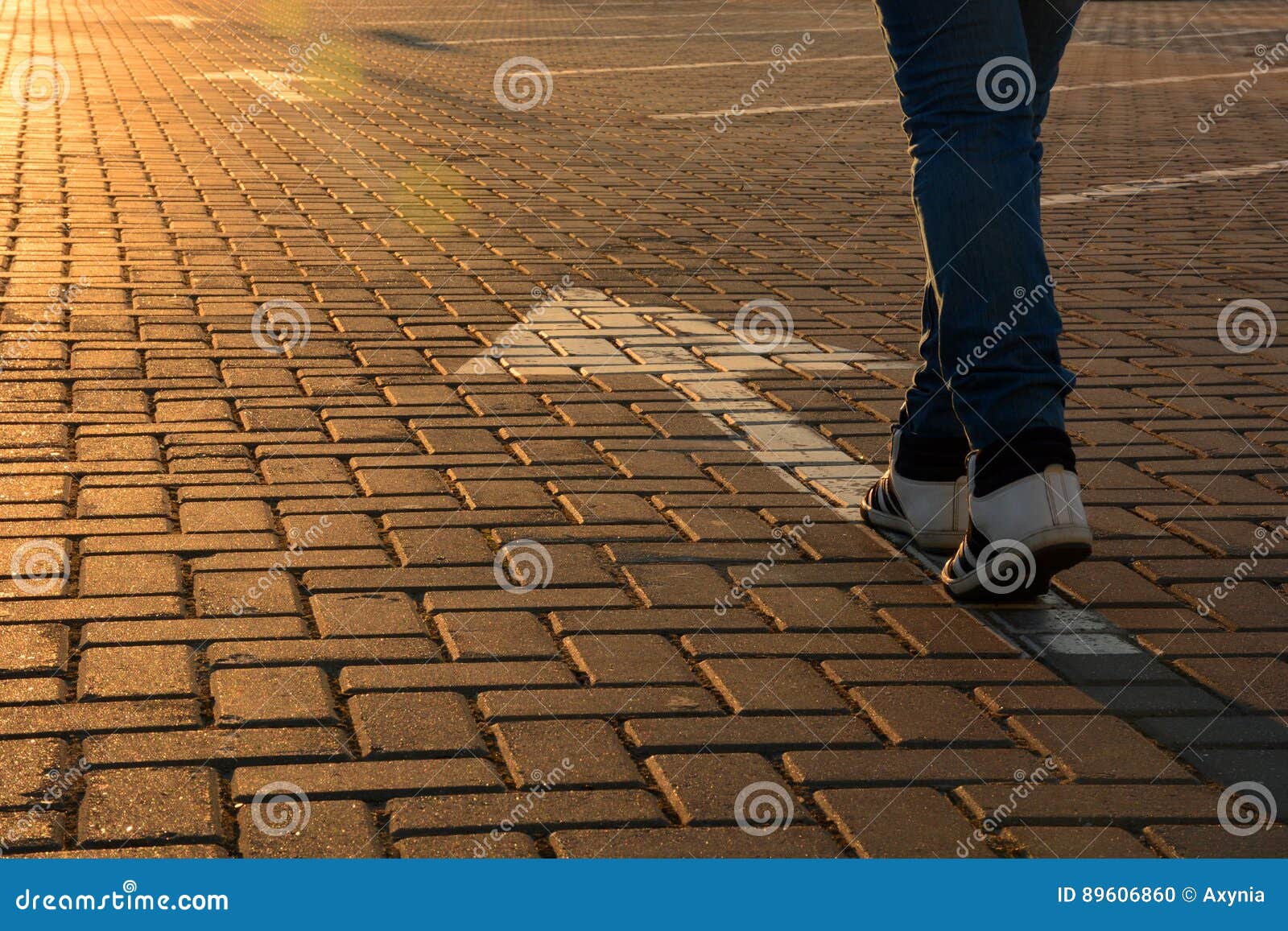 forward movement. feet on the road with arrows in the rays of the setting sun