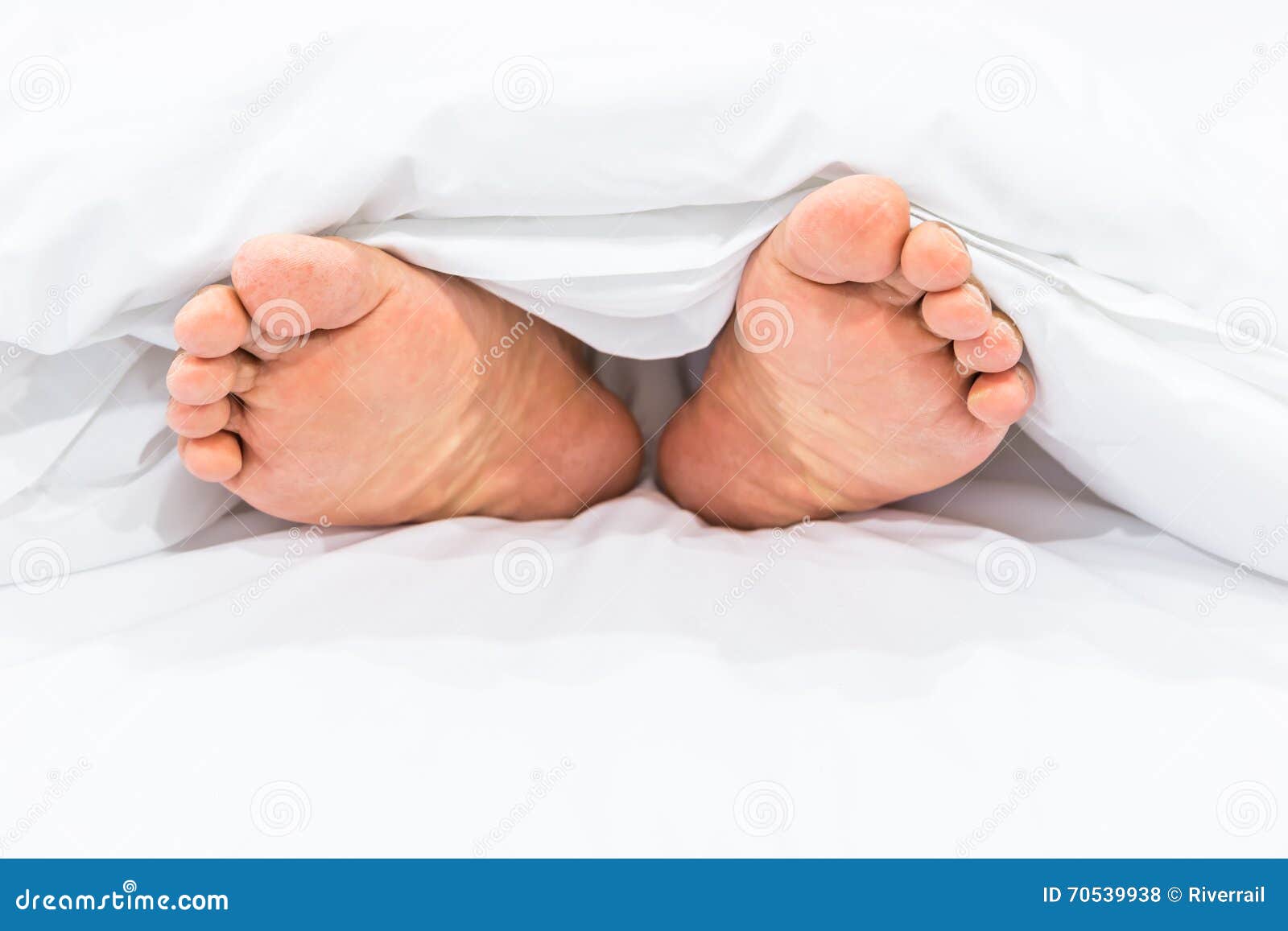 Feet under the blanket stock photo. Image of comforter 70539938