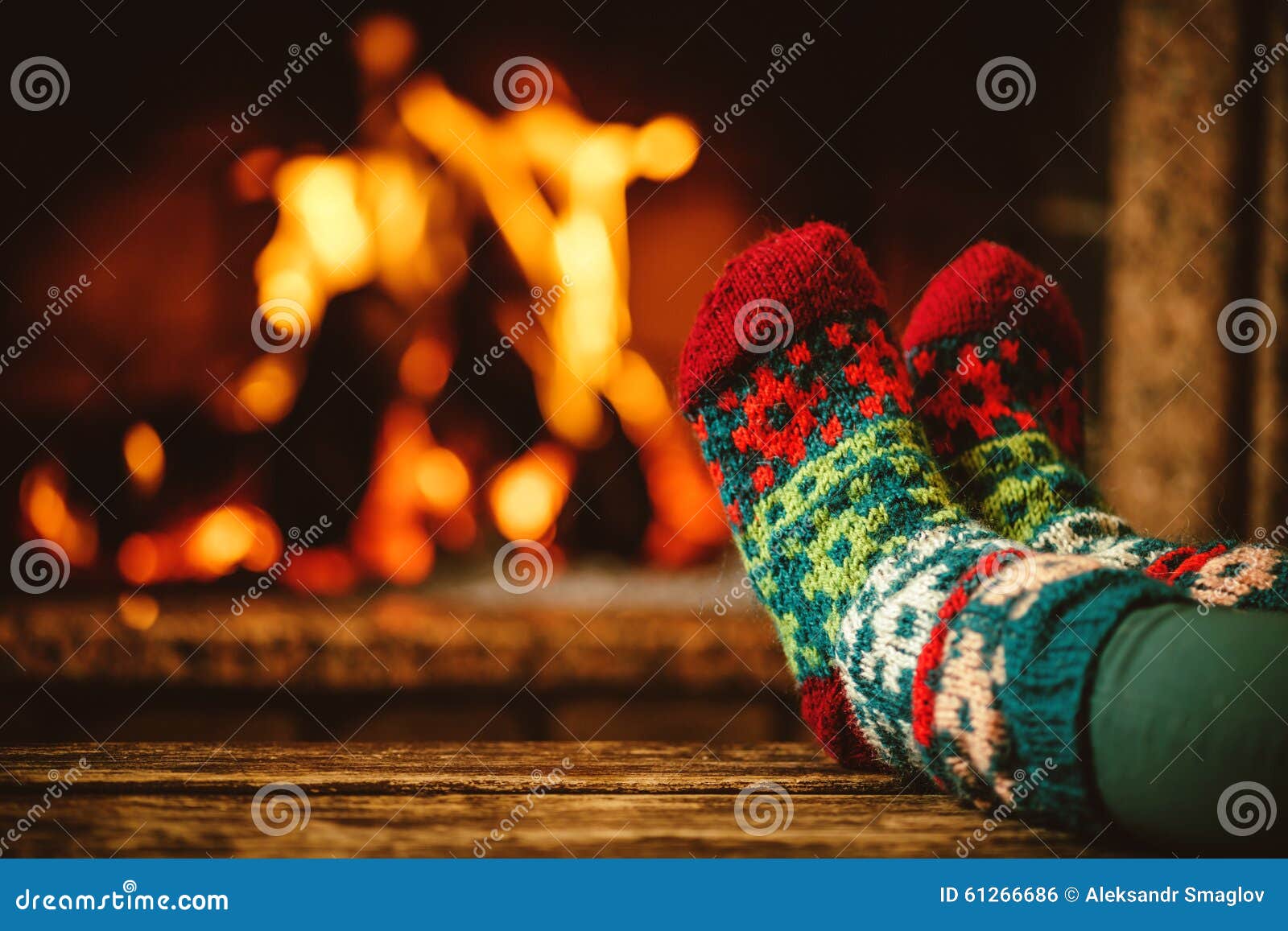 feet in woollen socks by the fireplace. woman relaxes by warm