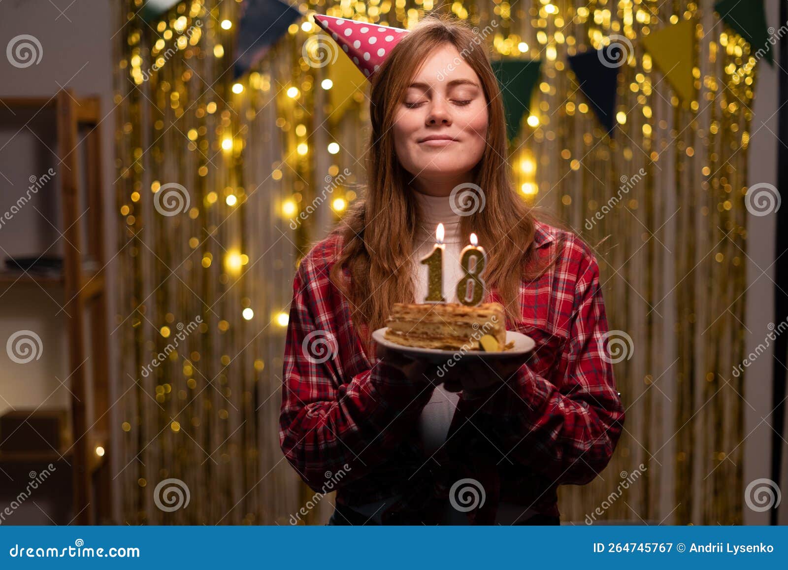 Feliz Chica De 18 Años En El Cono De Fiesta Hace Un Deseo Y Soplando Velas  En El Pastel De Cumpleaños Celebra El Cumpleaños En Cas Imagen de archivo -  Imagen de