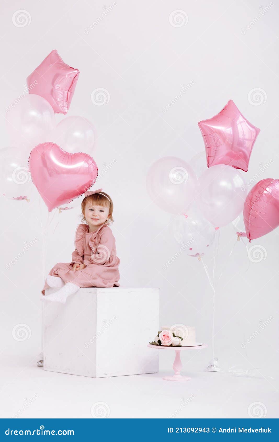 feliz cumpleaños niña de 2 años con vestido rosa. pastel blanco con velas y  rosas. Decoración de cumpleaños con globos de color blanco y rosa y c  Fotografía de stock - Alamy