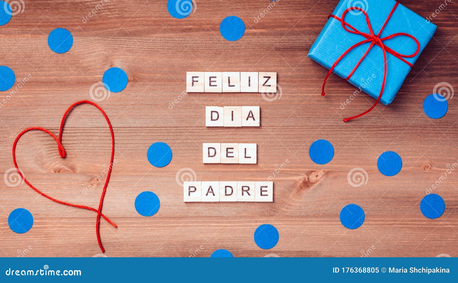 feliz dia del padre words made of wooden blocks with blue gift boxes and red hearts on wooden background. happy fathers day