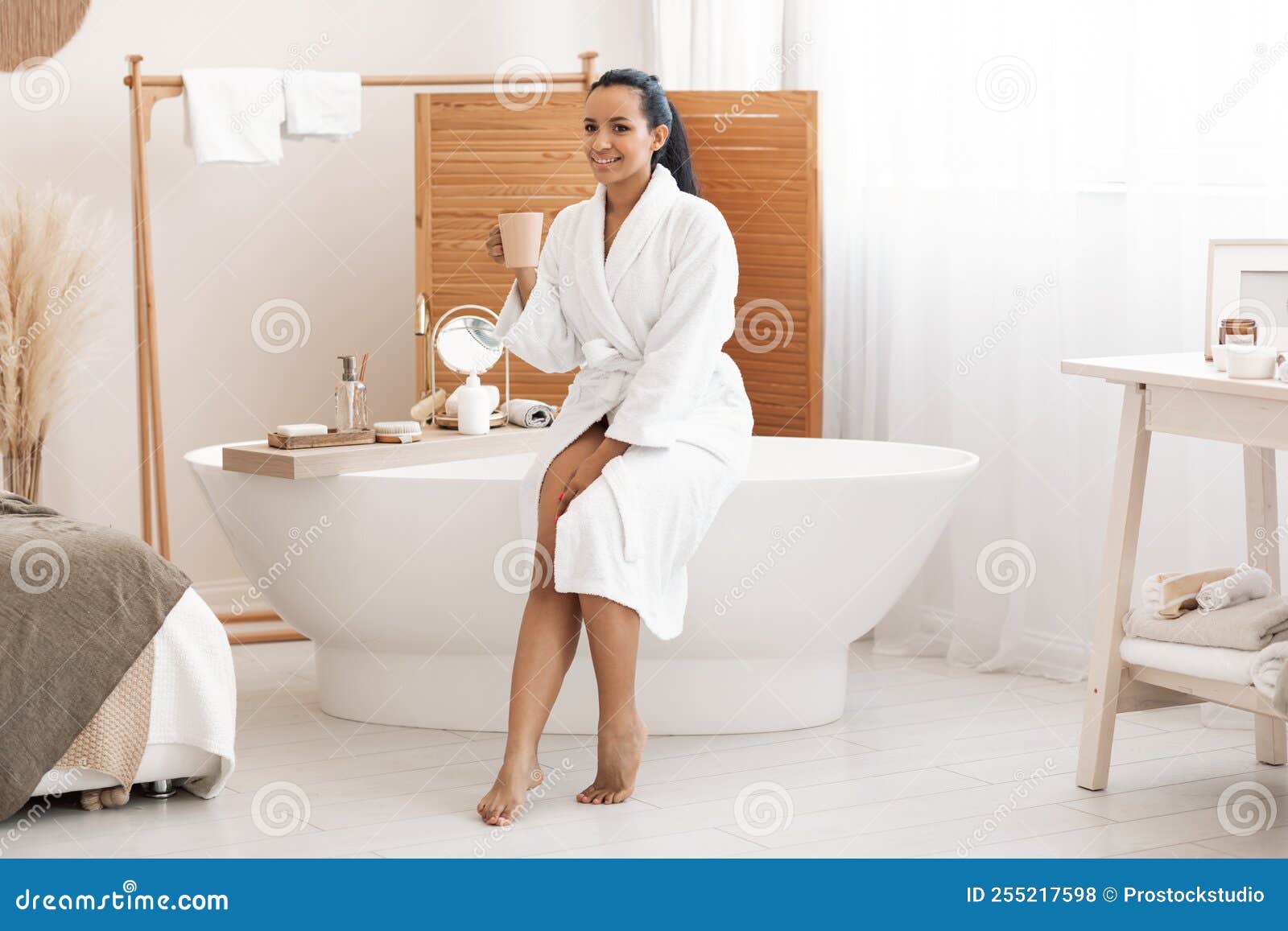Feliz Mujer Mixta Tomando Café Disfrutando Del Autocuidado En El Baño  Moderno Foto de archivo - Imagen de rutina, femenino: 255217598