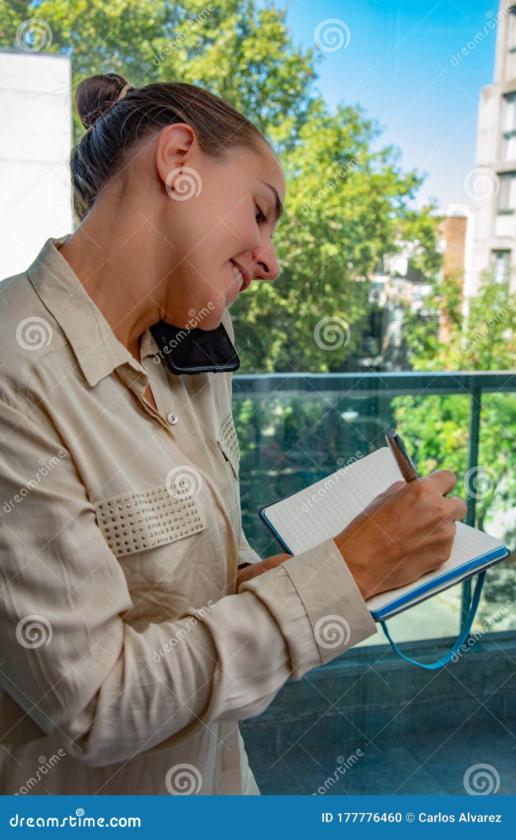 Female Administrative Assistant Taking Notes and Answering the Cell