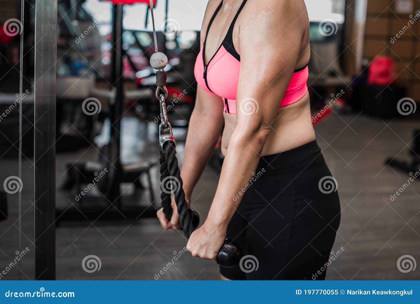 female adults doing pull ups on bar in cross fit training gym