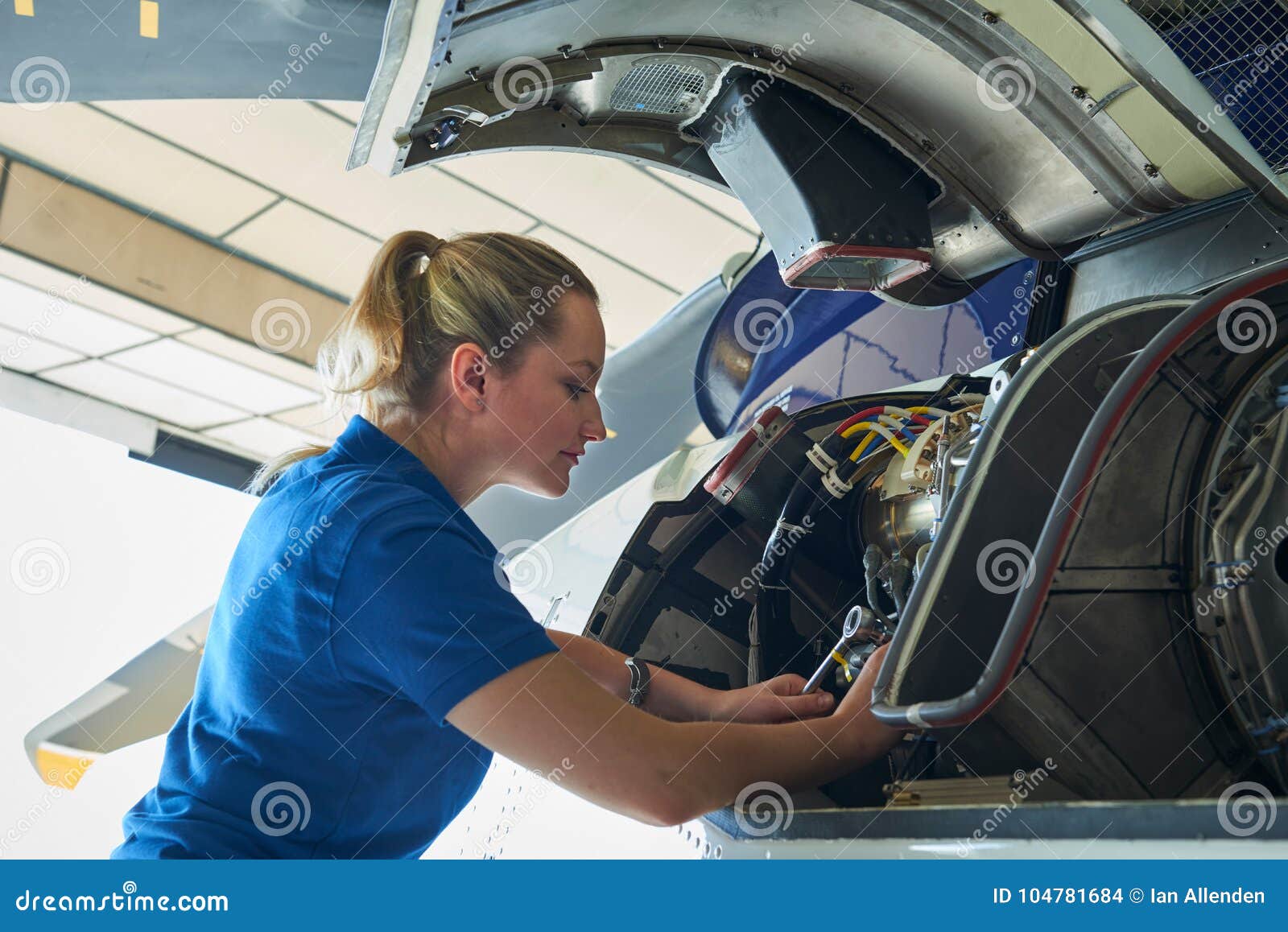 female aero engineer working on helicopter in hangar