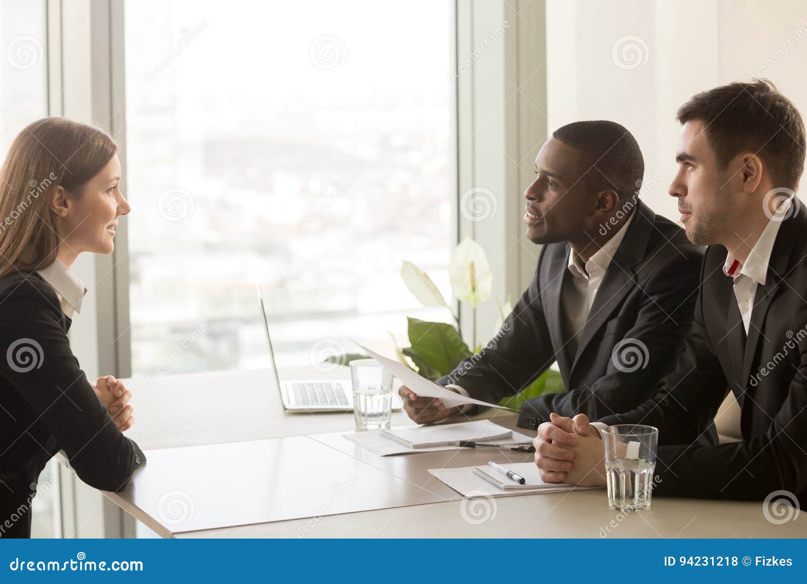female applicant and multiracial recruiters during job interview