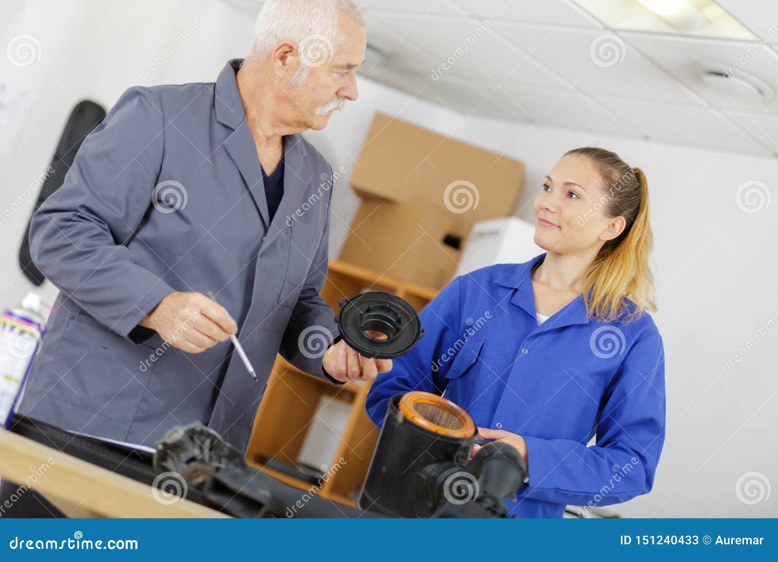 Female Apprentice Mechanic with Teacher Looking at Parts Stock Image