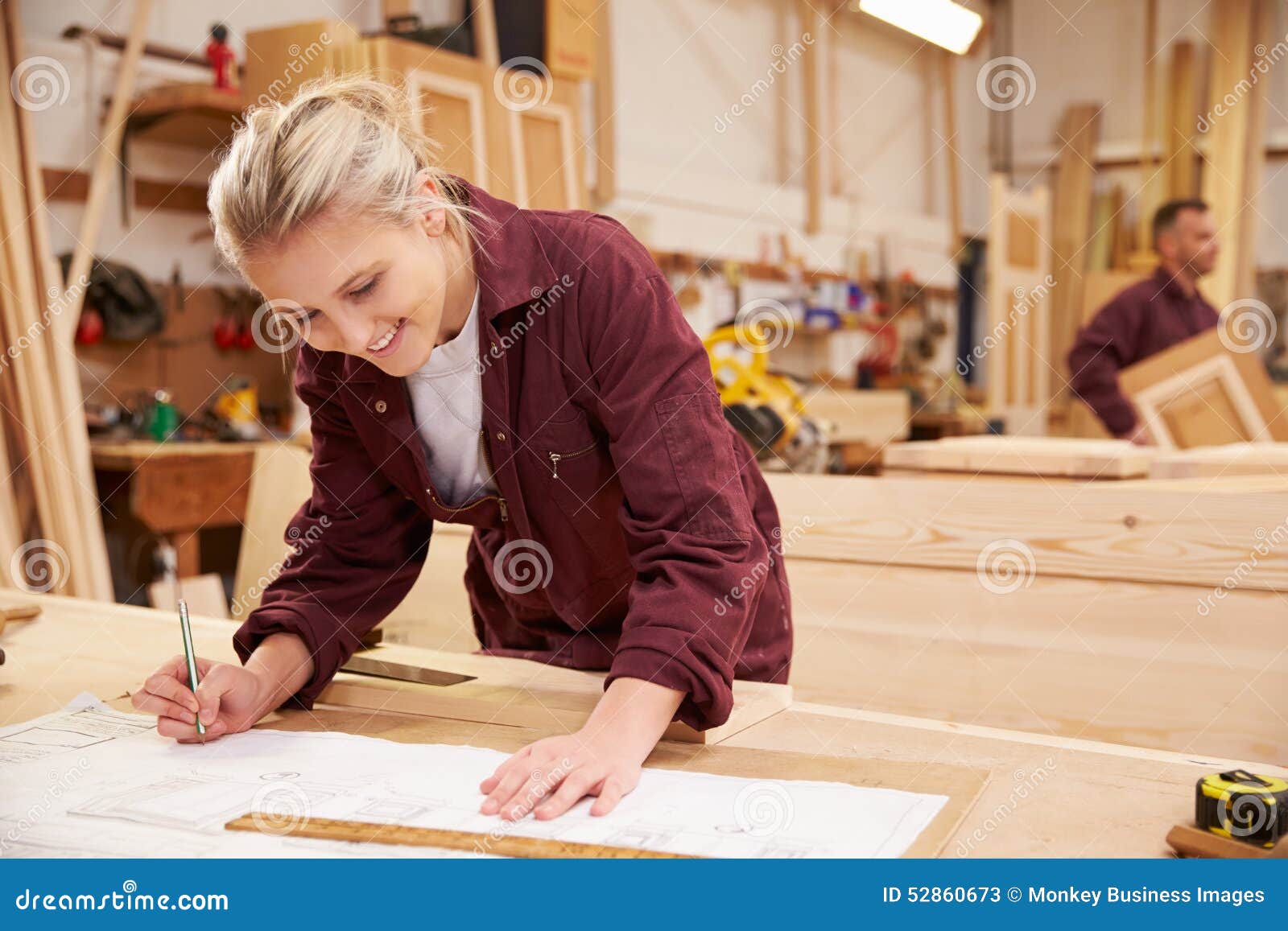 Female Apprentice Working with Plans in Carpentry Stock Image
