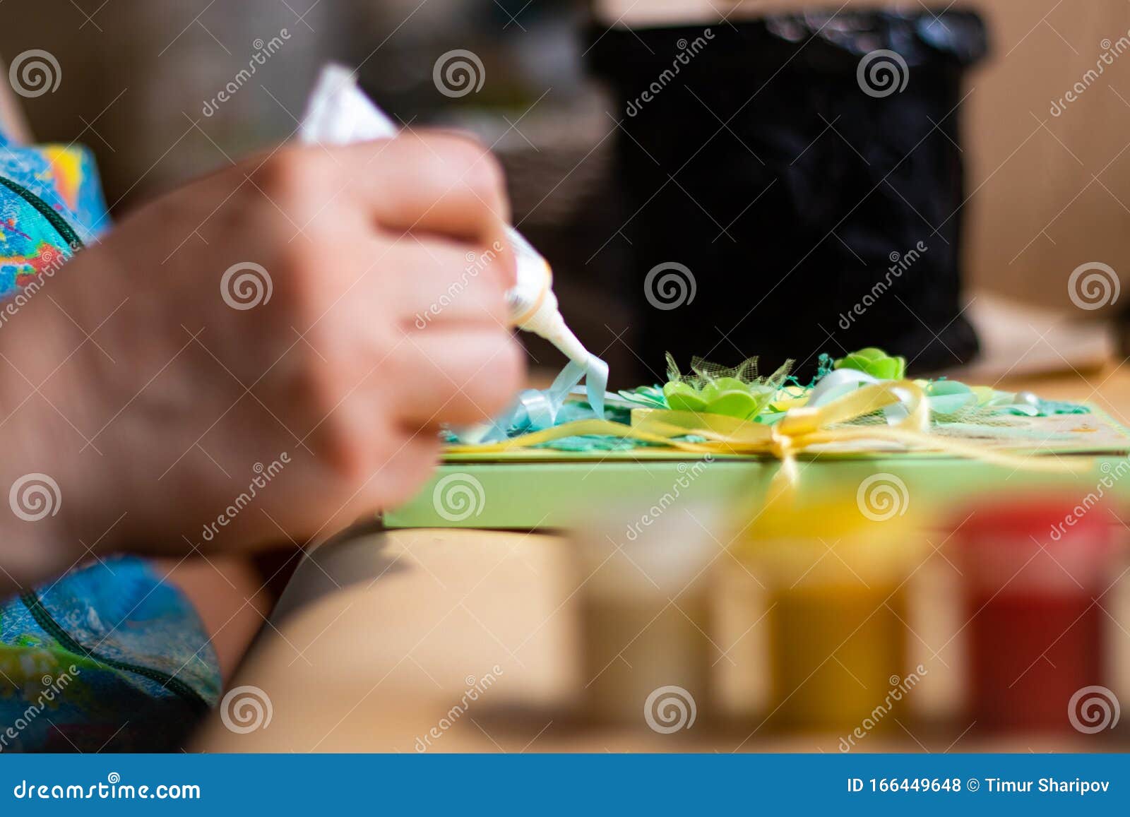 Female Artist is Using a Glue on the Handmade Artwork Stock Photo