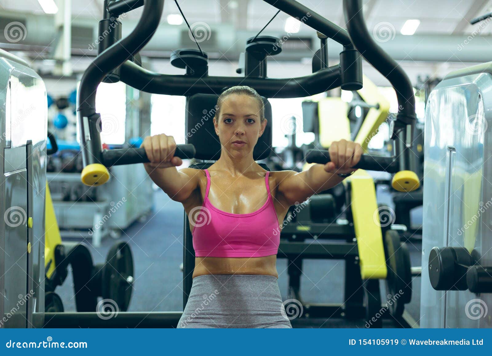 Female Athlete Exercising with Chest Press Machine in Fitness