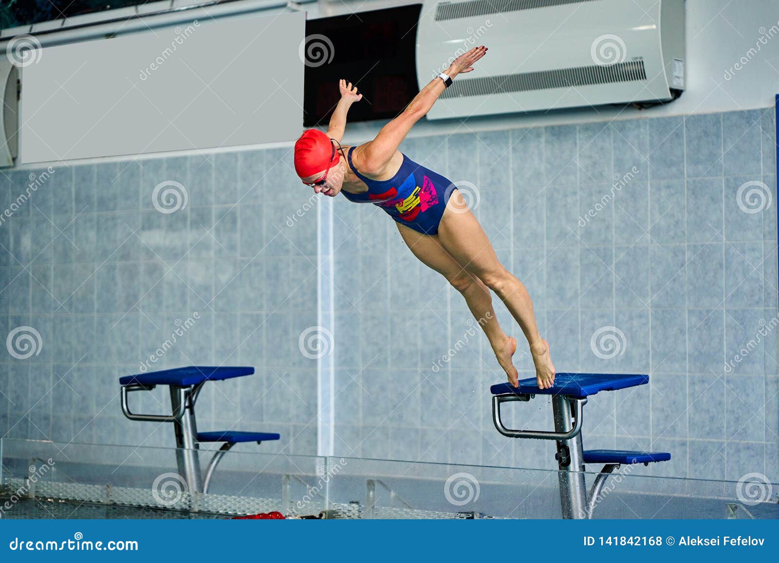 female athlete jumps to the pool water. middle-aged woman professionally engaged in swimming