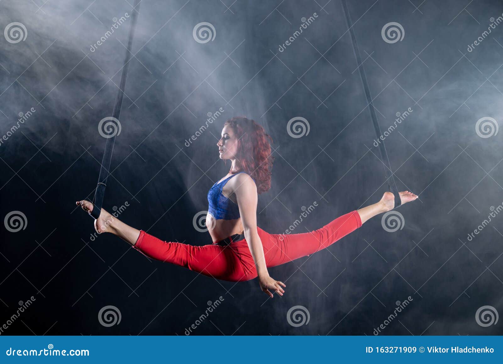Female Athletic And Flexible Aerial Circus Artist With Redhead On Aerial Straps On Black