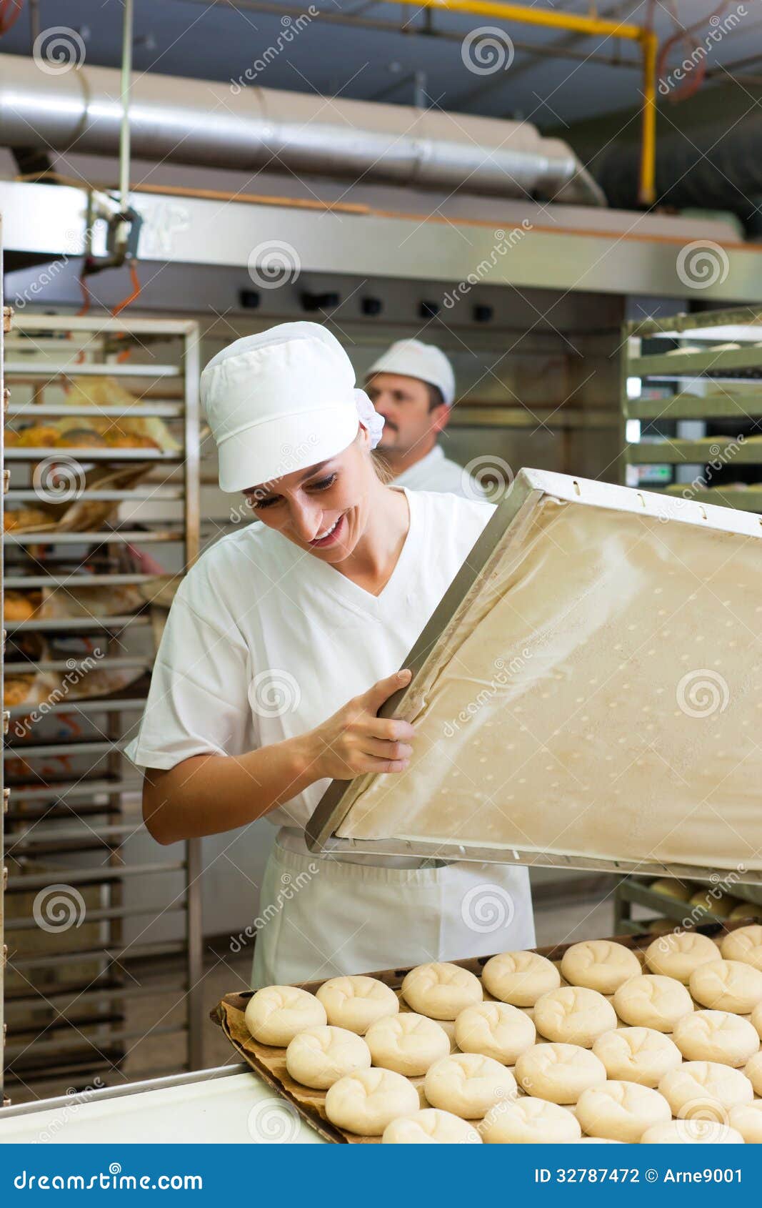 female baker baking bread rolls