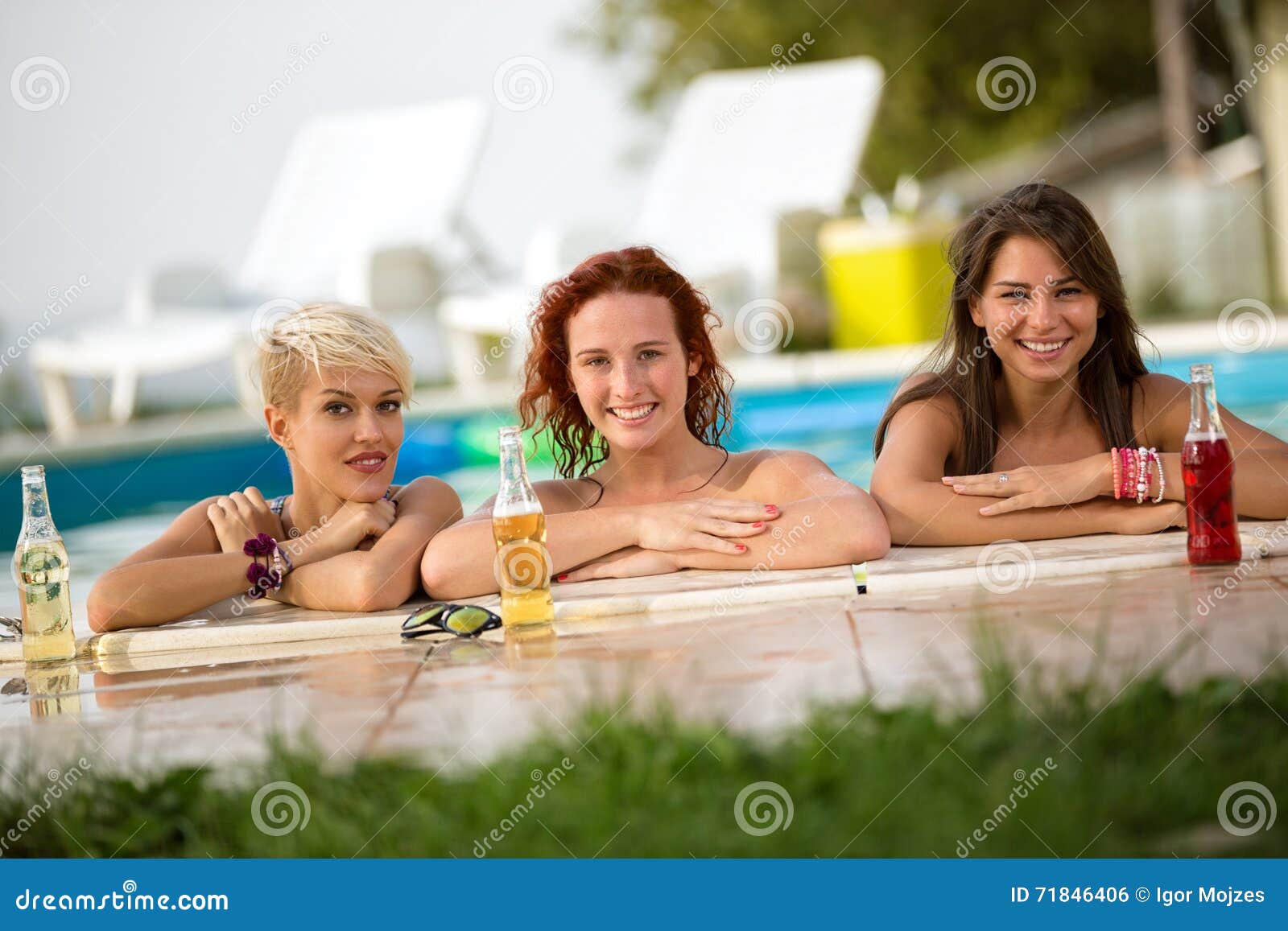 female bathers standing in front of railing of pool with bottles