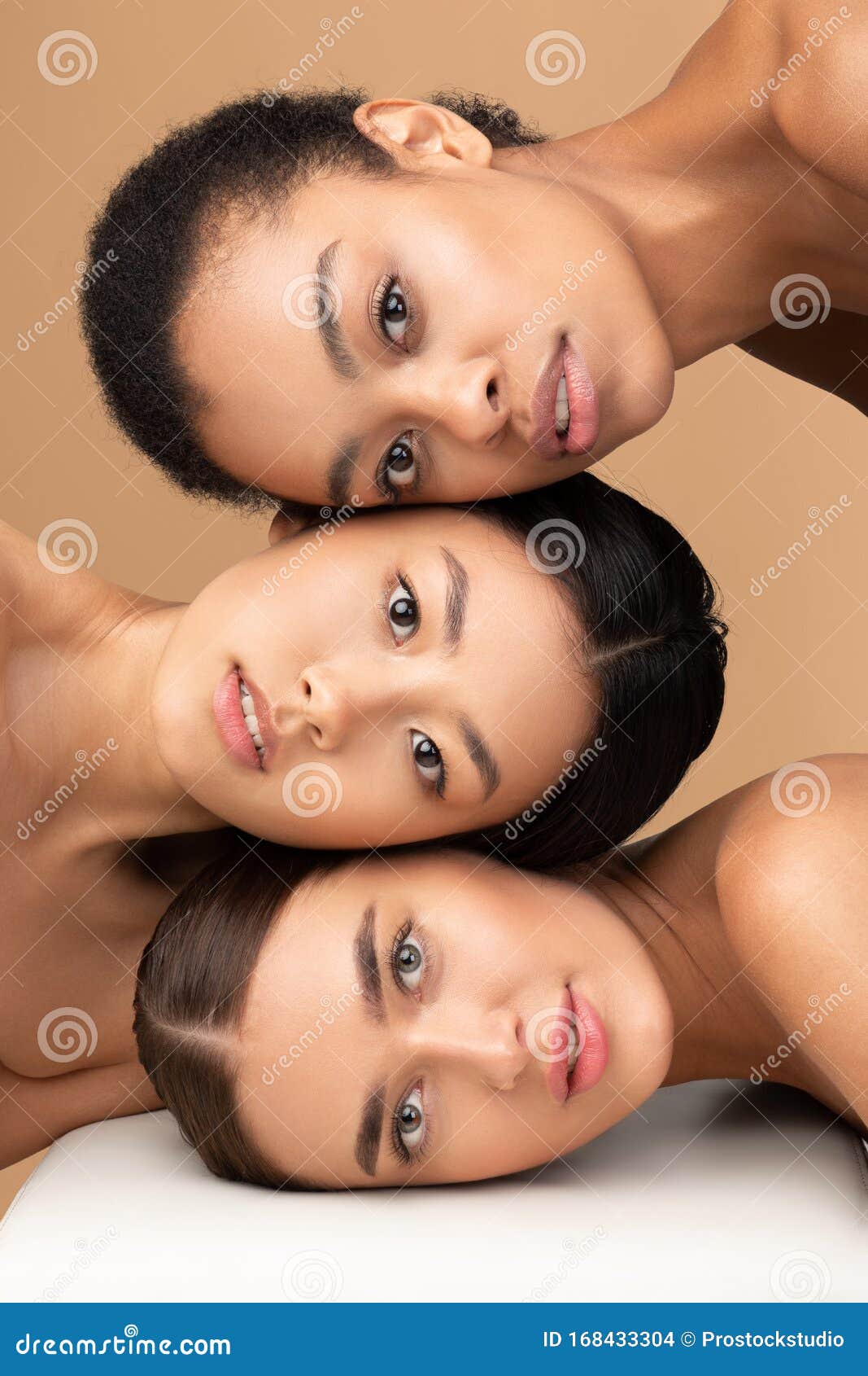 Cheerful millennial latin, arab women in underwear hugs, isolated on beige  background Stock Photo by Prostock-studio