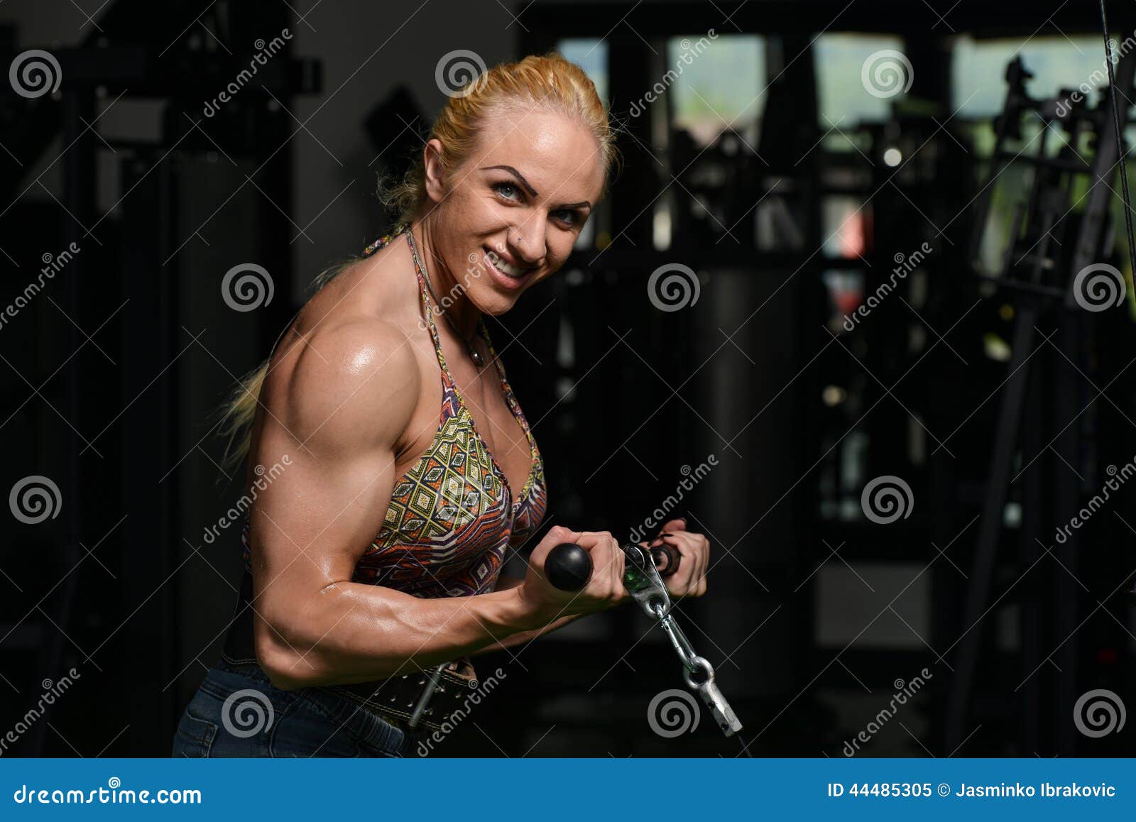 Portrait Of Young Fitness Woman Shows Biceps. Muscular Female Body