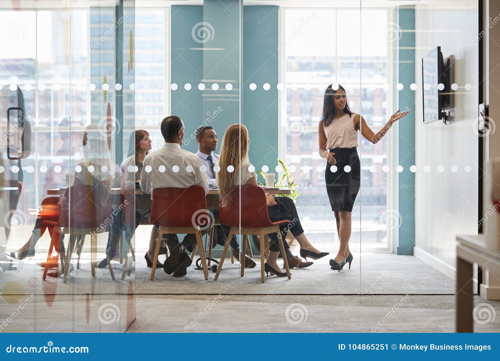 female boss shows presentation on screen at business meeting