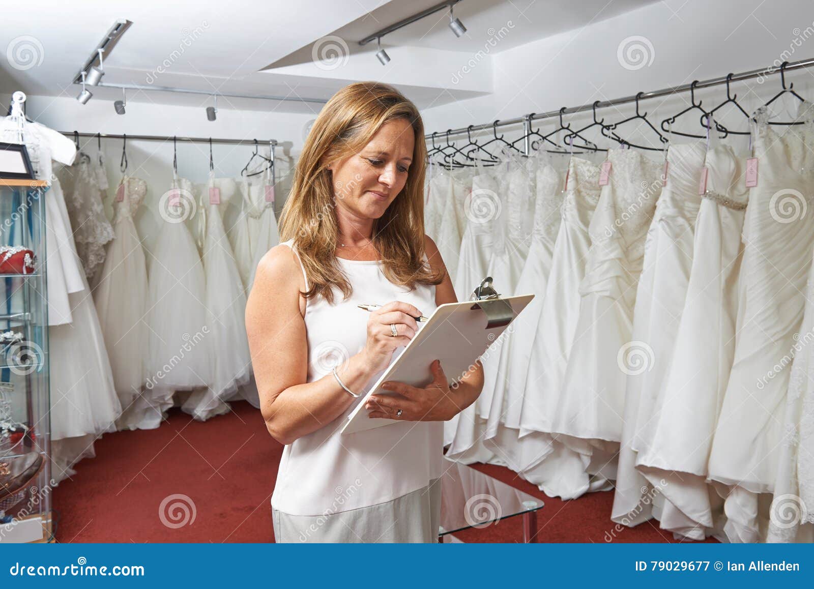 Female Bridal  Store  Owner  With Wedding  Dresses  Stock Photo 