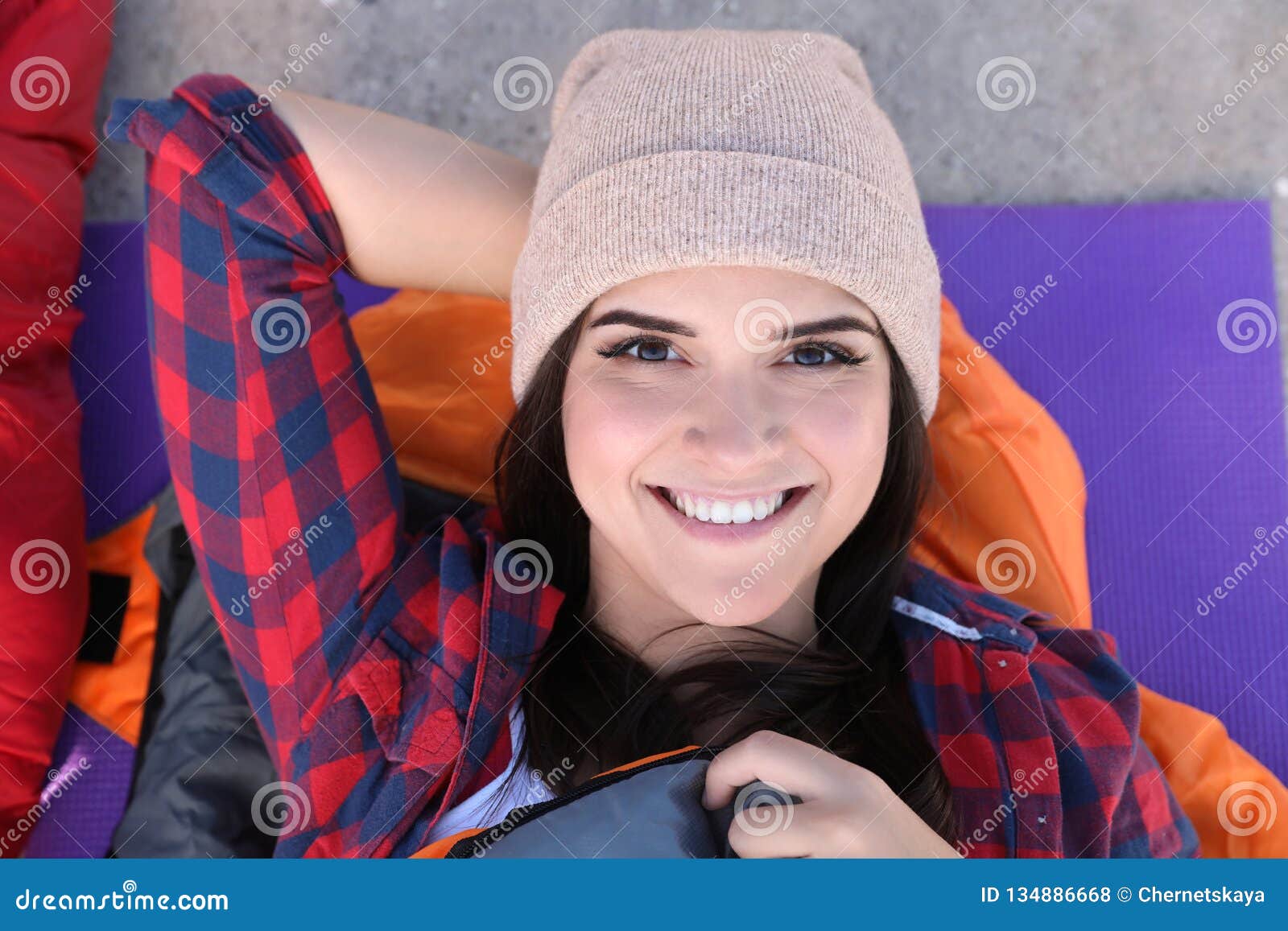 Female Camper With Thermos Sitting On Sleeping Bag RoyaltyFree Stock