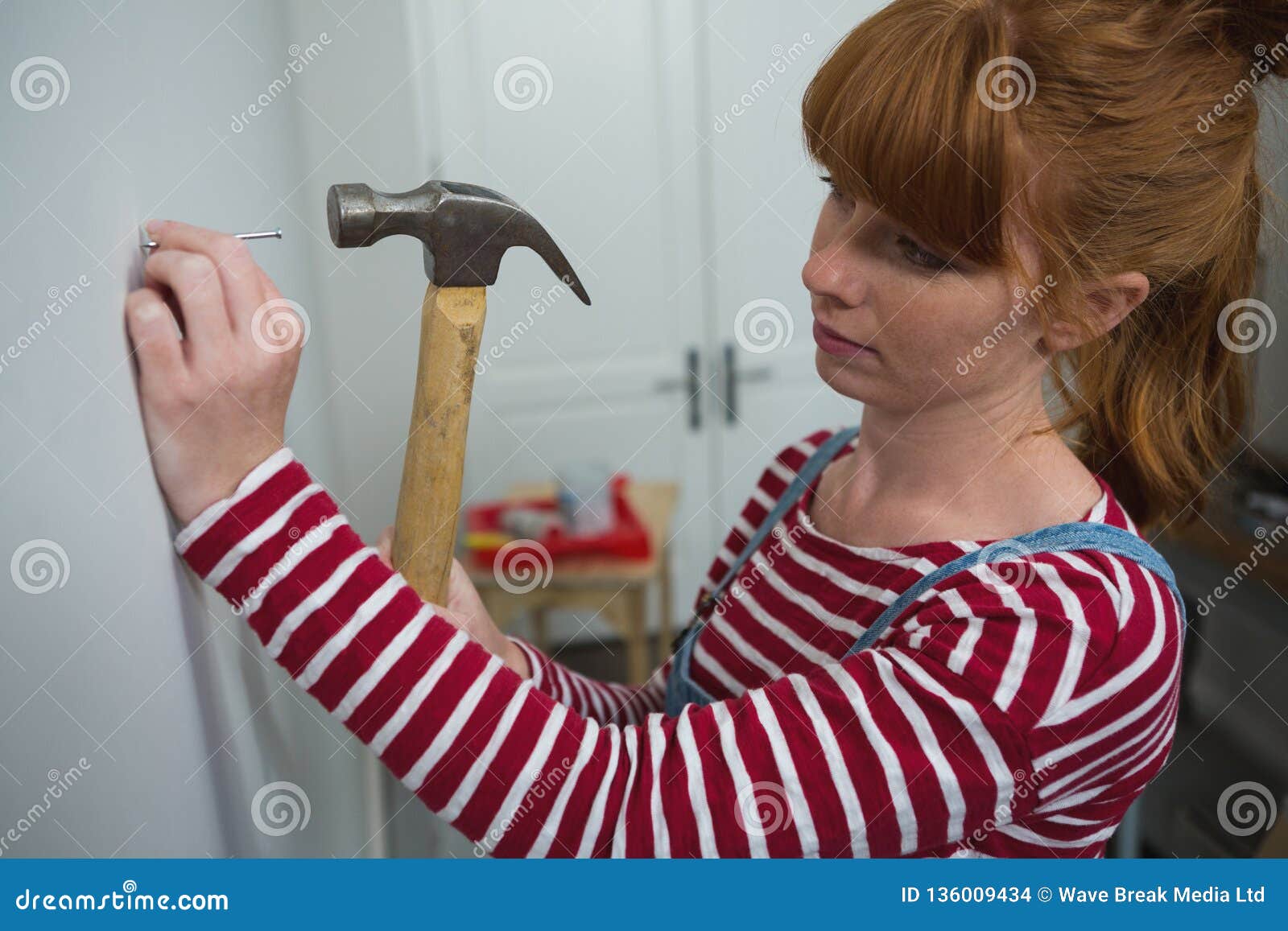 Female Carpenter Hammering Nail on Wall Stock Photo - Image of indoors,  carpenter: 136009434