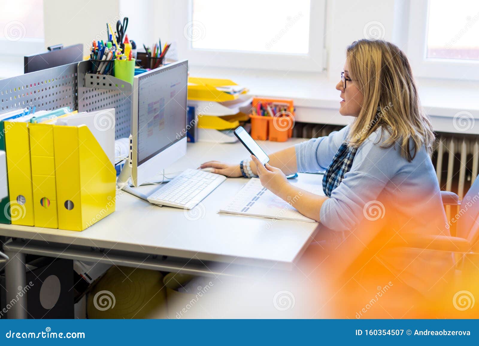 female child therapist in an office during a phone call, using online calendar to schedule patients appointments. calendar planner