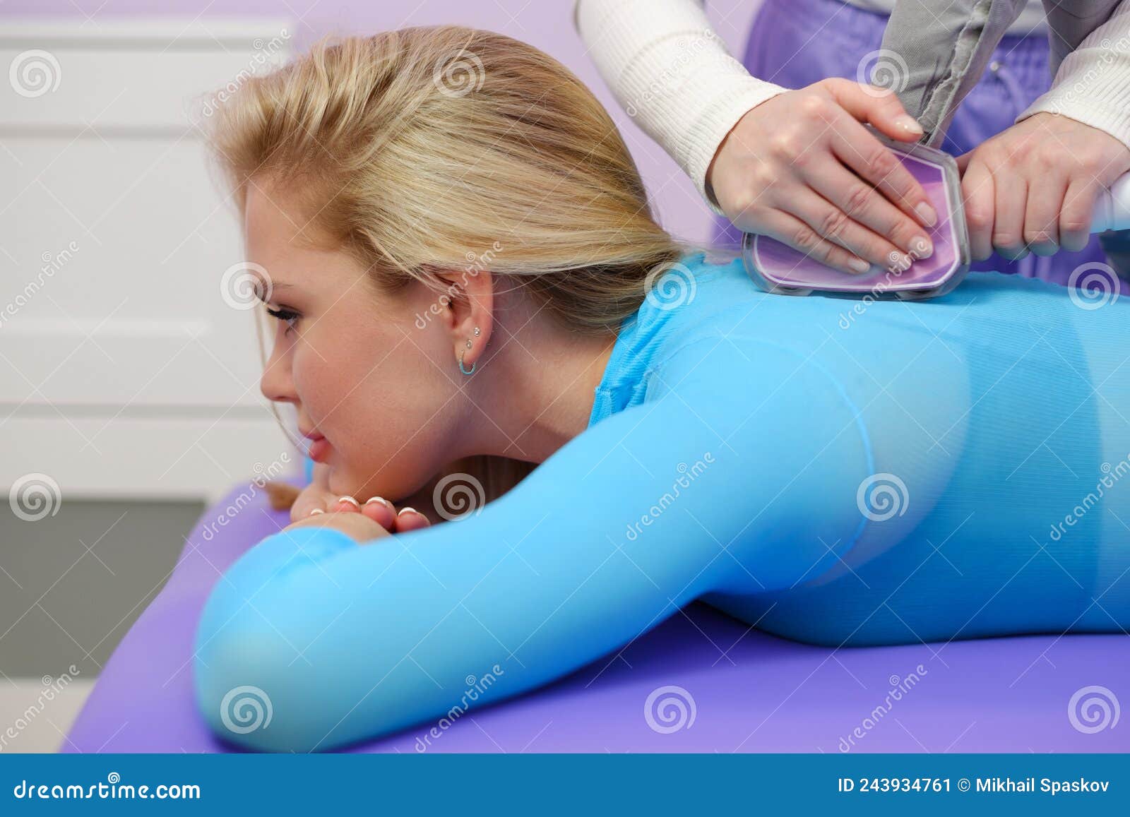 A Female Client Receives LPG Massage in Beauty Clinic. Parlour. Blue Suit. Lilac Background. Stock Image - Image of medical, female: 243934761