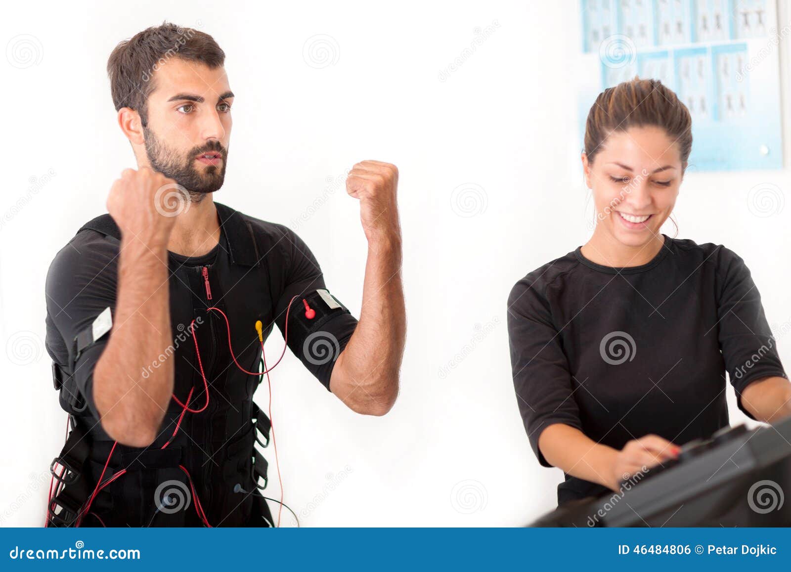 female coach giving man ems electro muscular stimulation exercise
