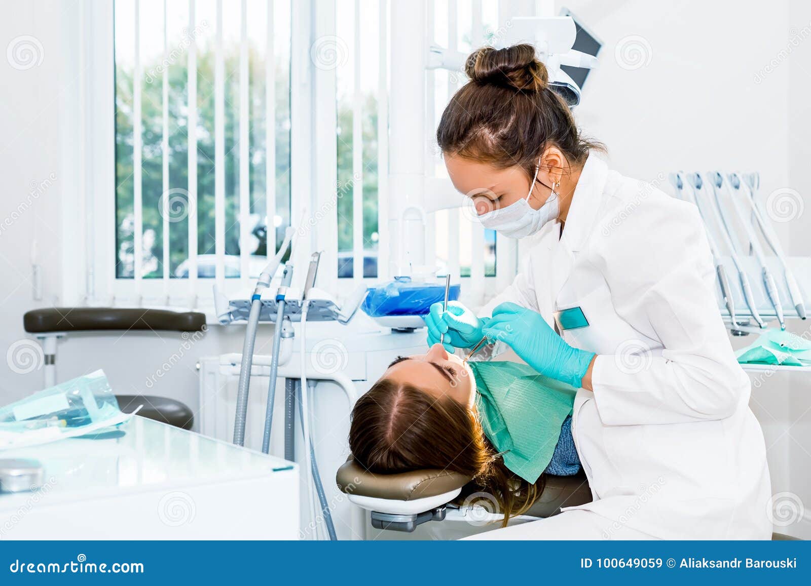 female dentist checking up patient teeth with braces at dental clinic office. medicine, dentistry concept. dental