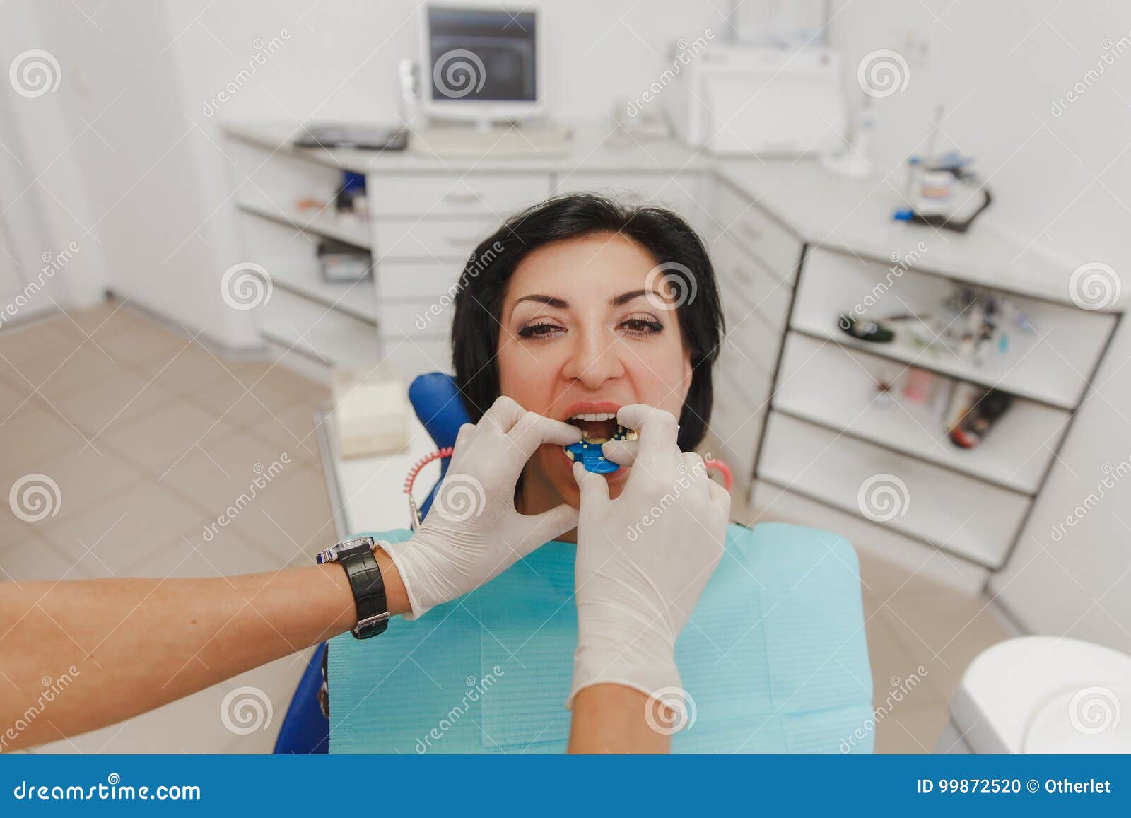 A Female Dentist is Installing in the Patient`s Mouth a Device for