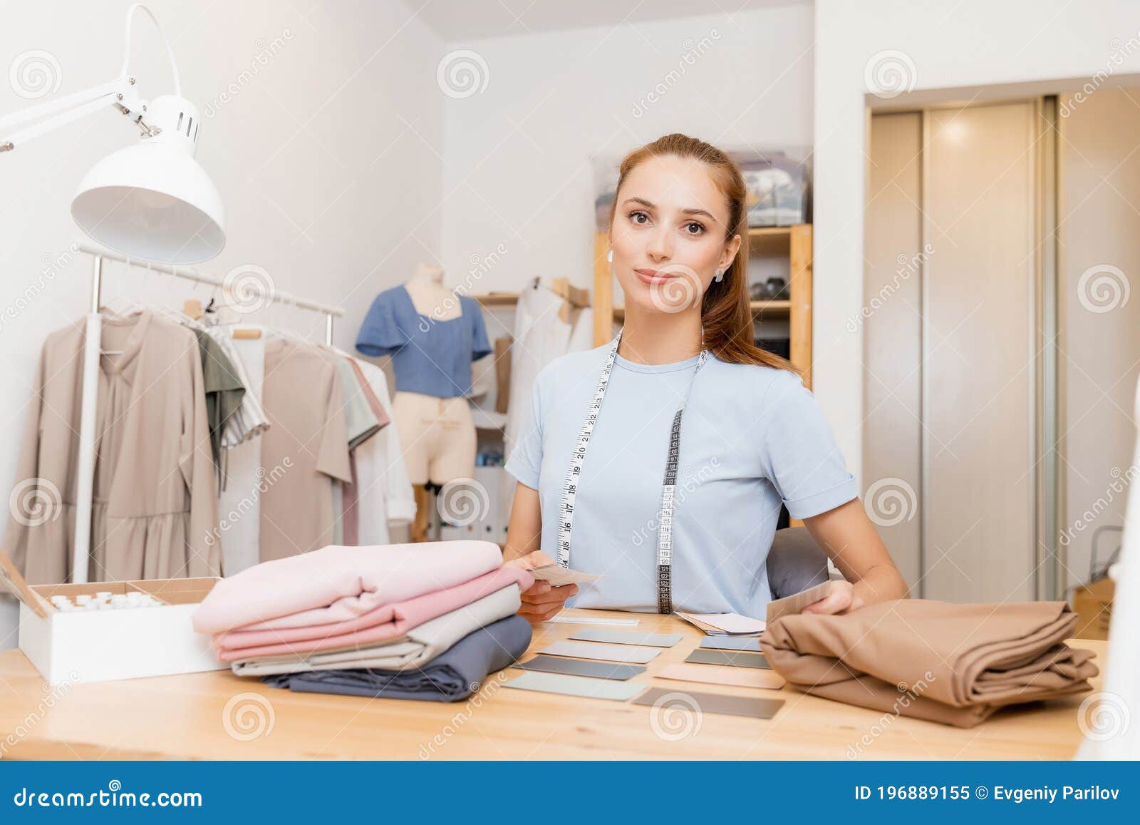 Female Designer Dressmaker Working on Sewing Machine in Studio. Forms ...