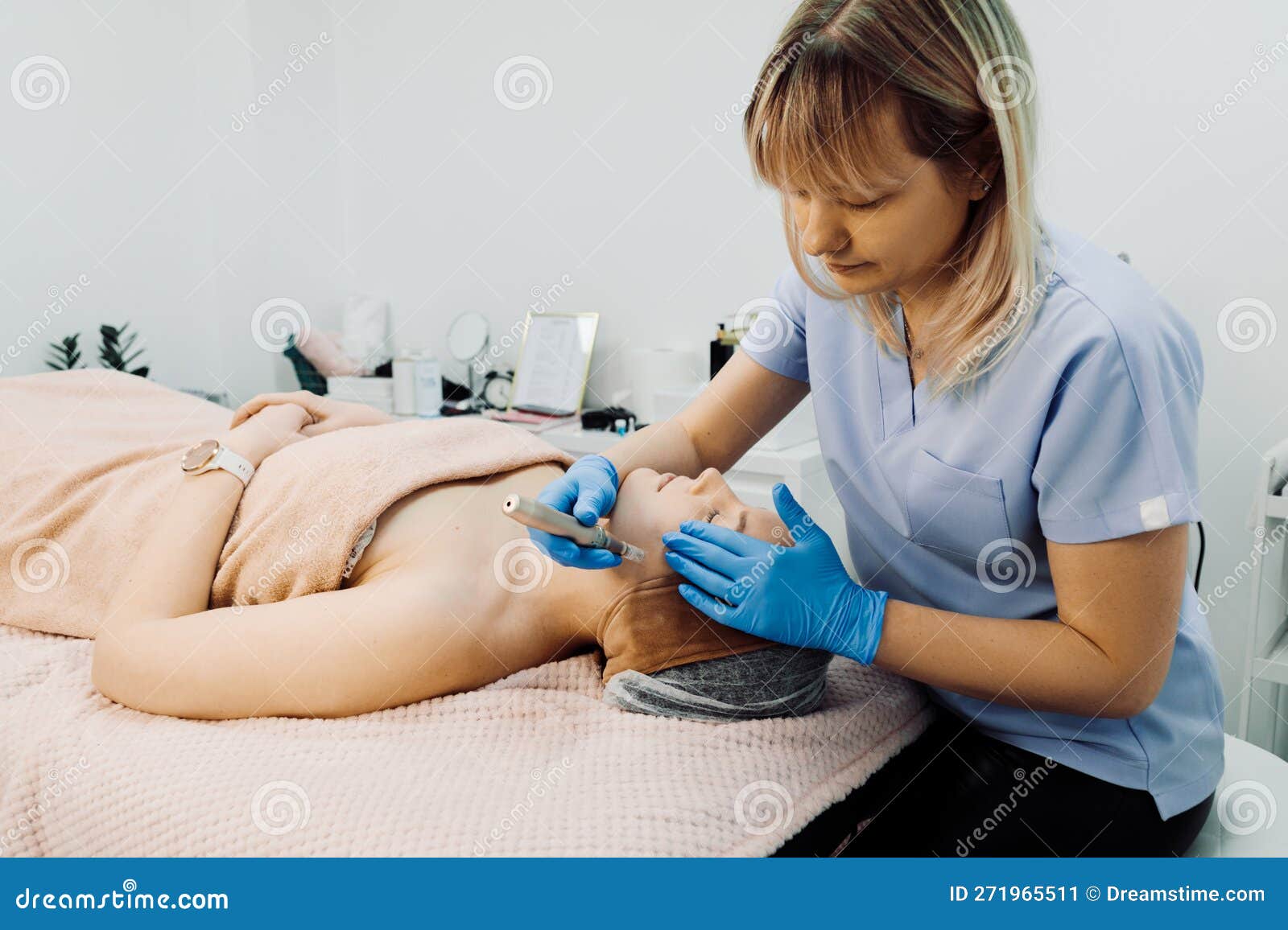 female doctor applying dermapen device for relaxed woman patient, lying on couch in spa clinic on beauty procedures