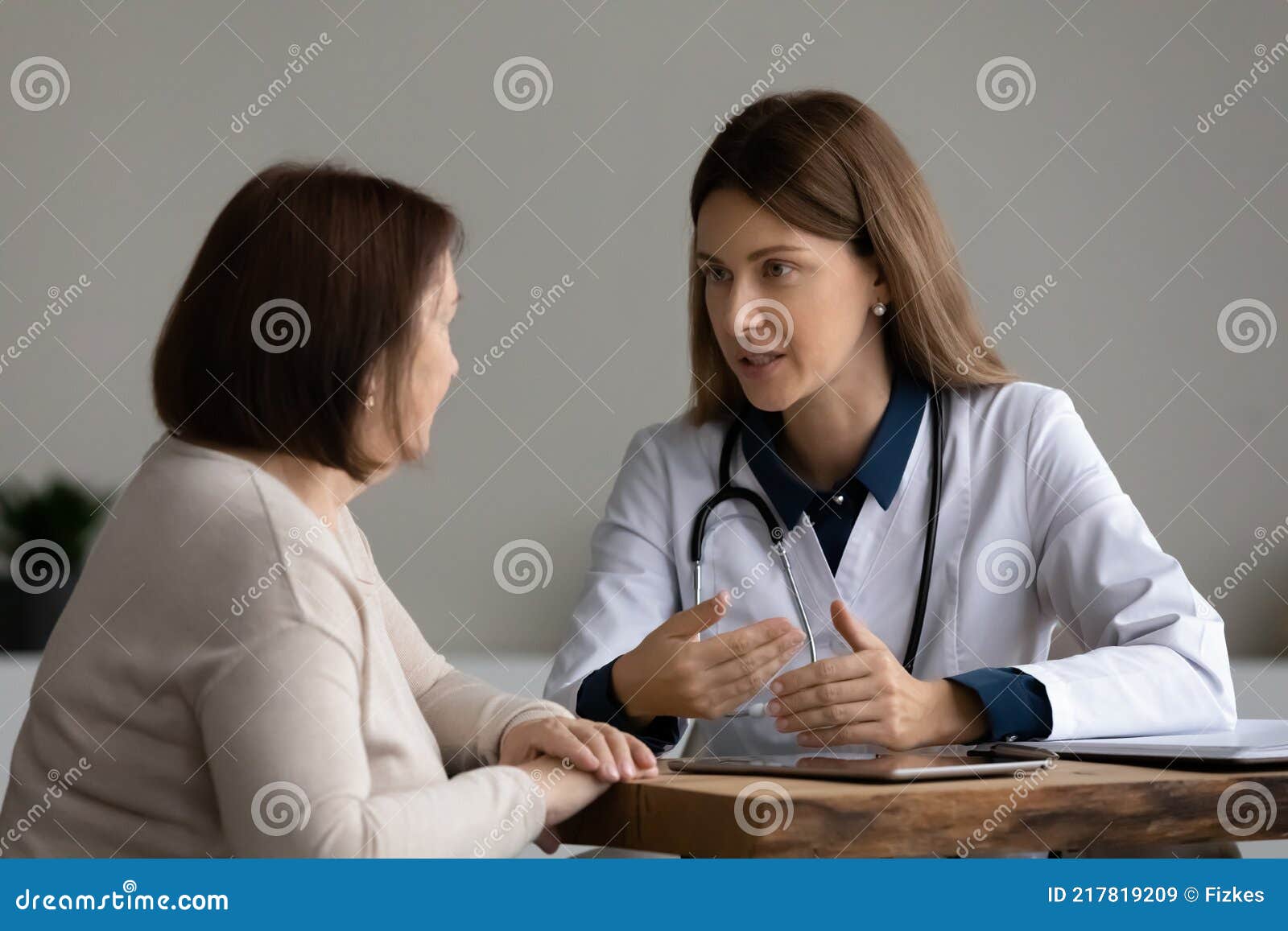 female doctor consult mature patient at clinic