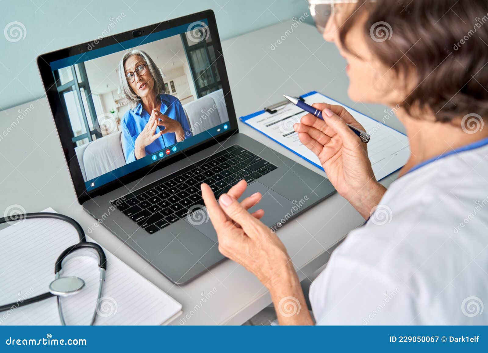 female doctor consulting older senior patient during virtual video call visit.