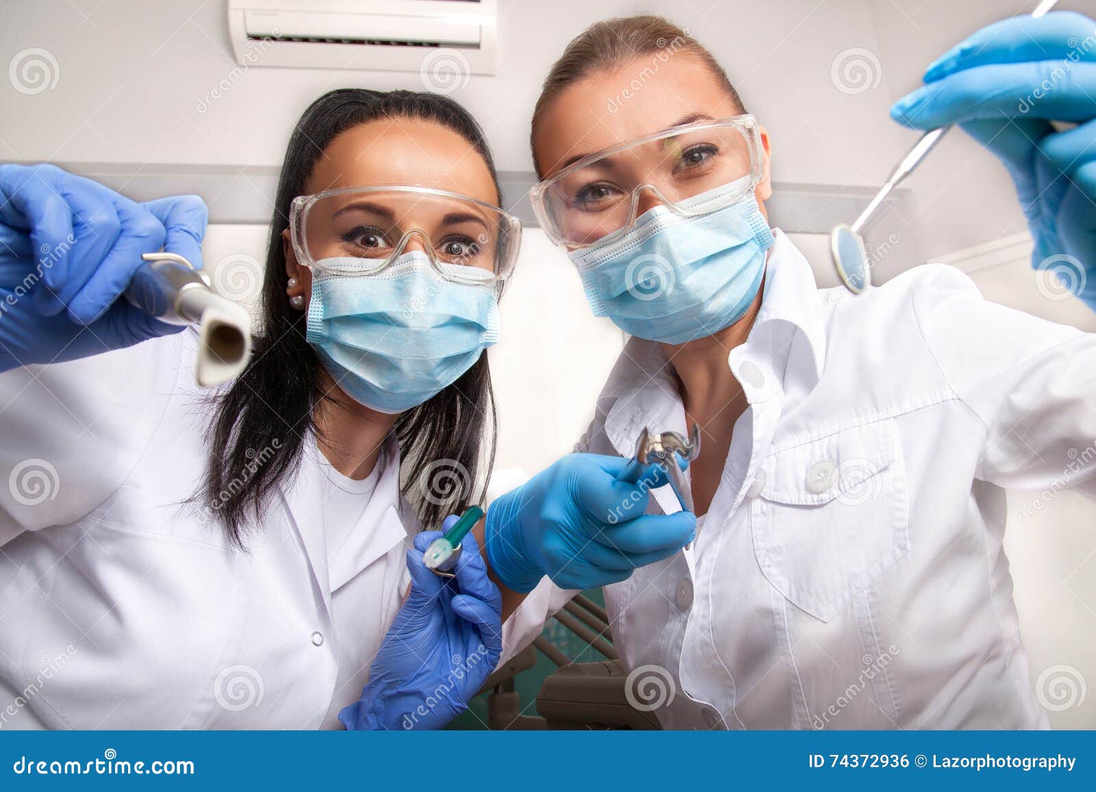 female doctor dentist and assistant in masks looking at camera