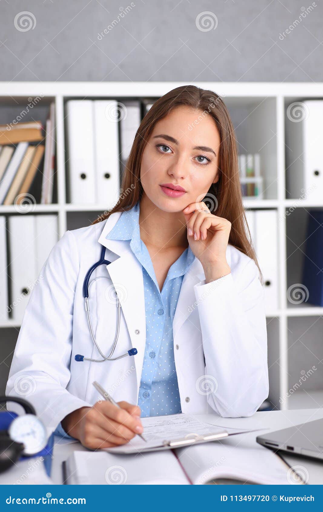 Female doctor hold hold in arm silver pen and pad during ward round check portrait. Medic exam aid visit and remedy prescribe for sick office business visitor with problem and complaint for anamnesis