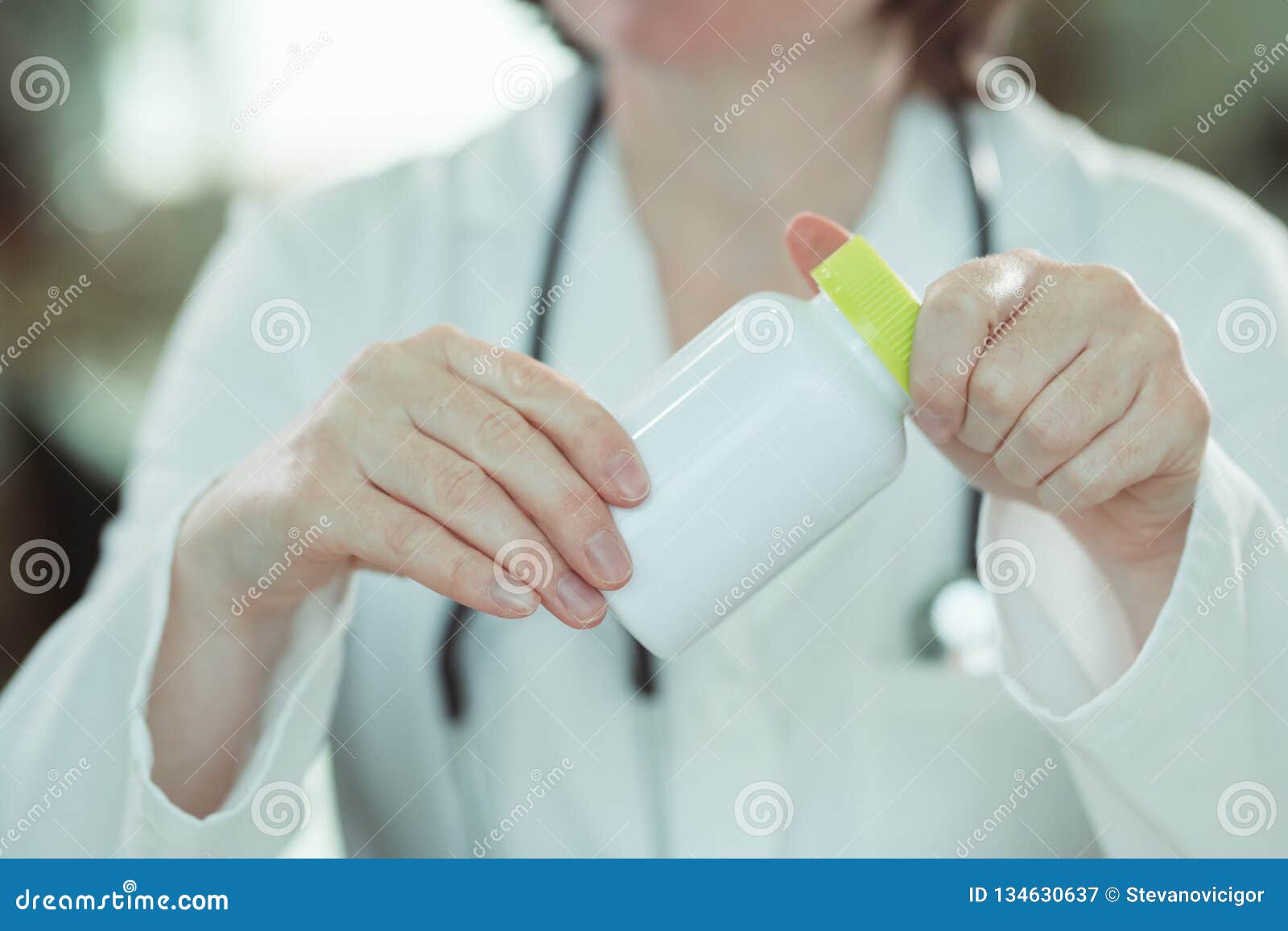 female doctor holding bottle of dietary supplement