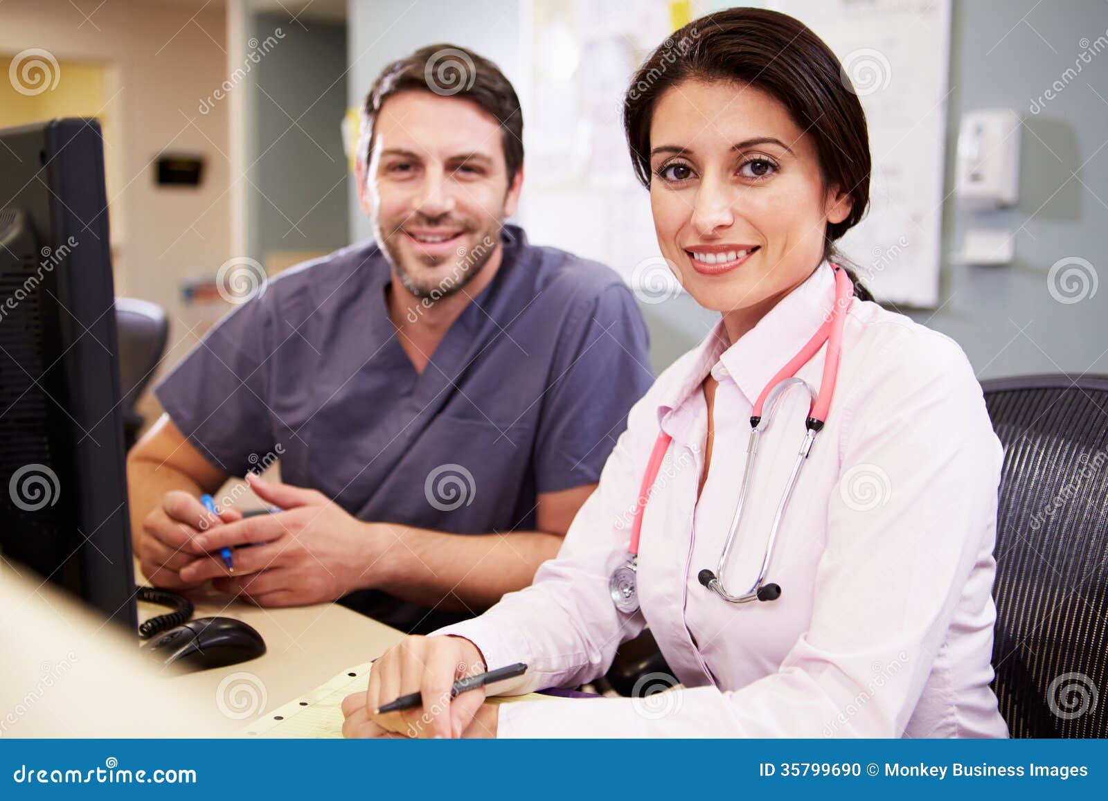 female doctor with male nurse working at nurses station