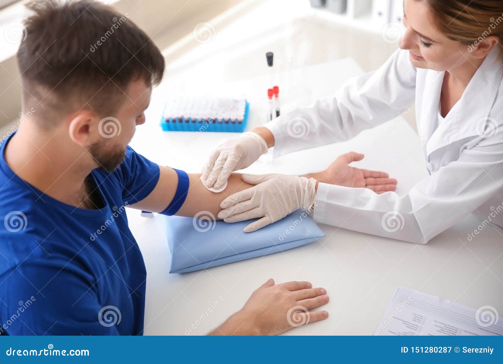 female doctor preparing patient for blood draw in clinic