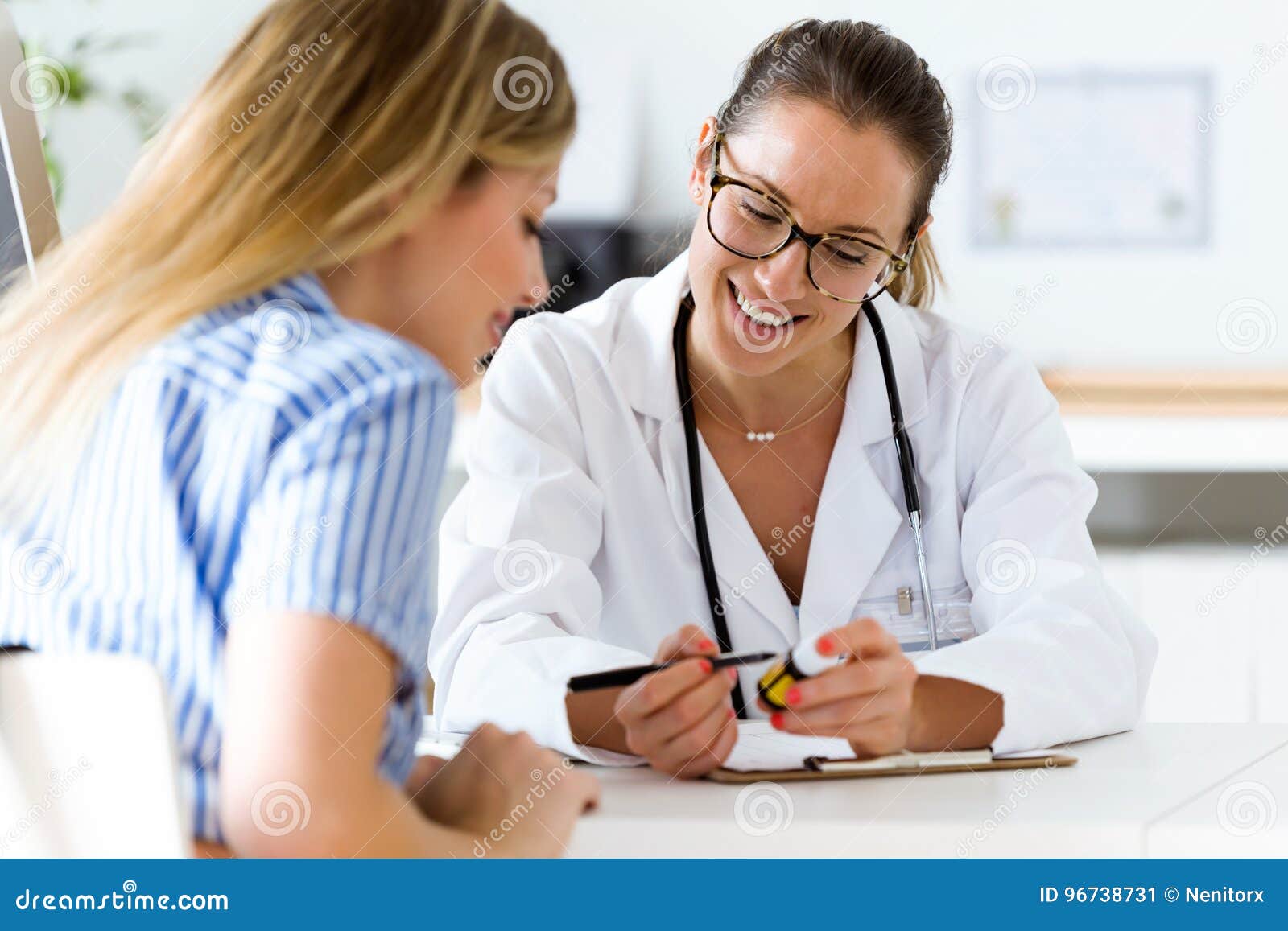 female doctor prescribing medication for patient.