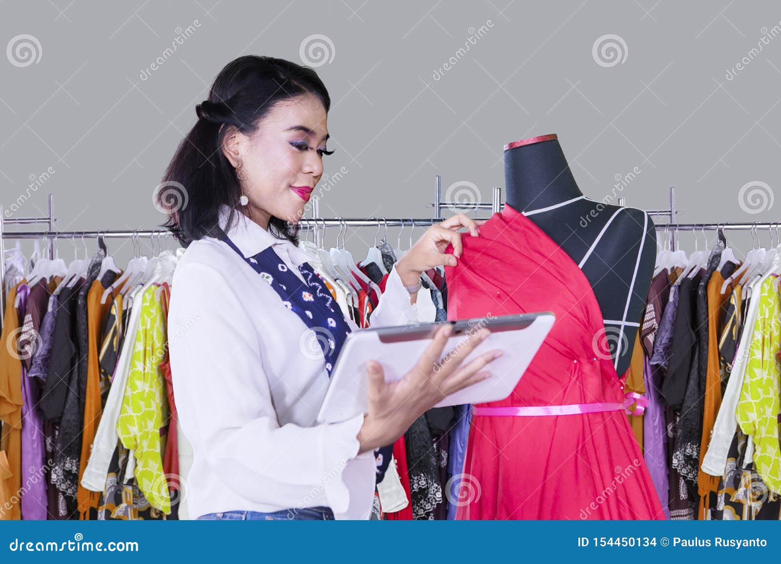 Female Dressmaker Works with Tablet and Mannequin Stock Photo Image