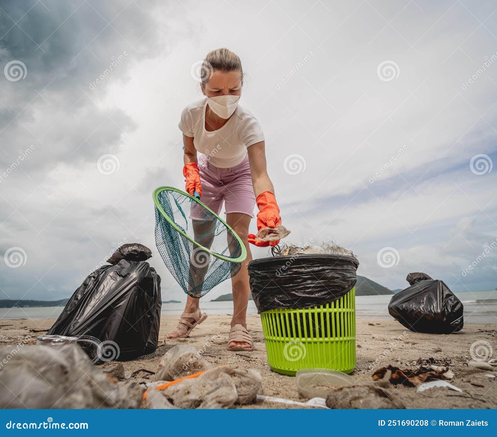 A Female Ecologist Volunteer Cleans the Beach on the Seashore from ...