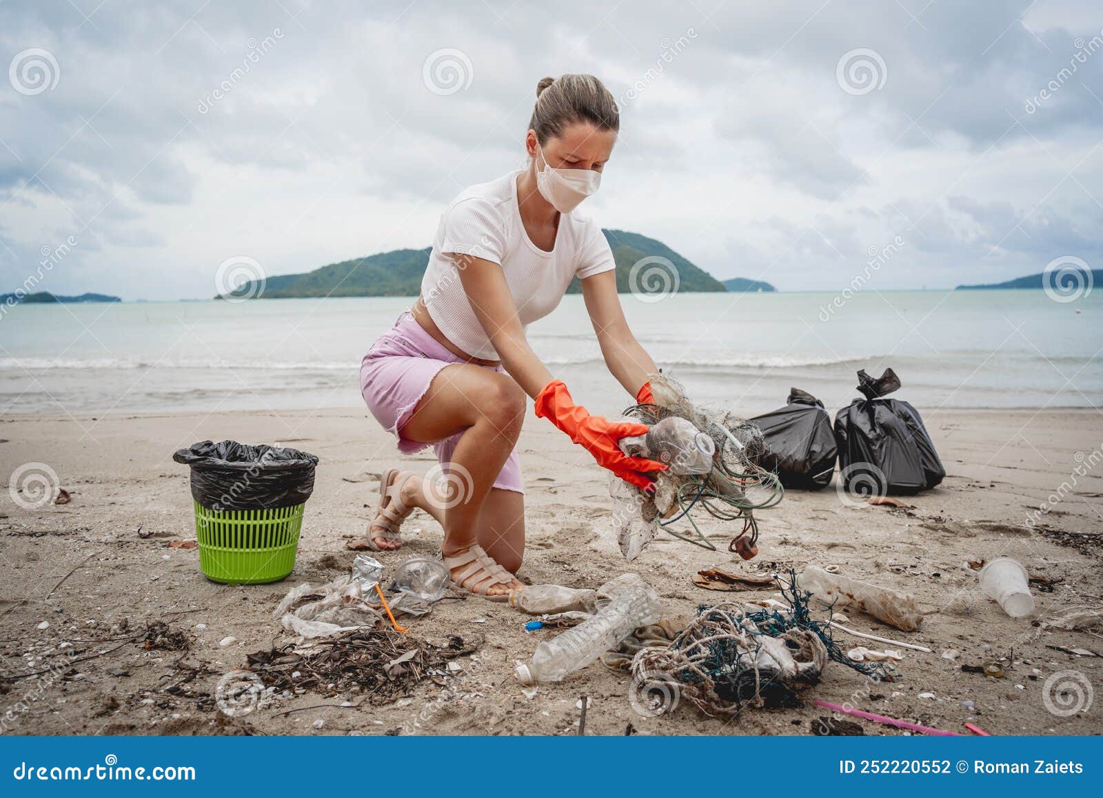 A Female Ecologist Volunteer Cleans the Beach on the Seashore from ...