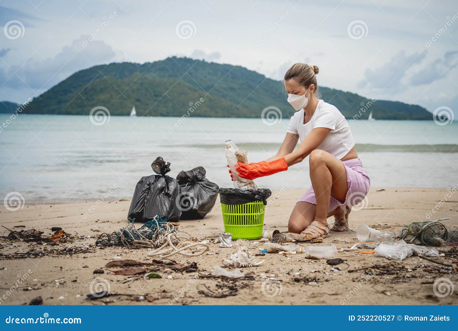 A Female Ecologist Volunteer Cleans the Beach on the Seashore from ...