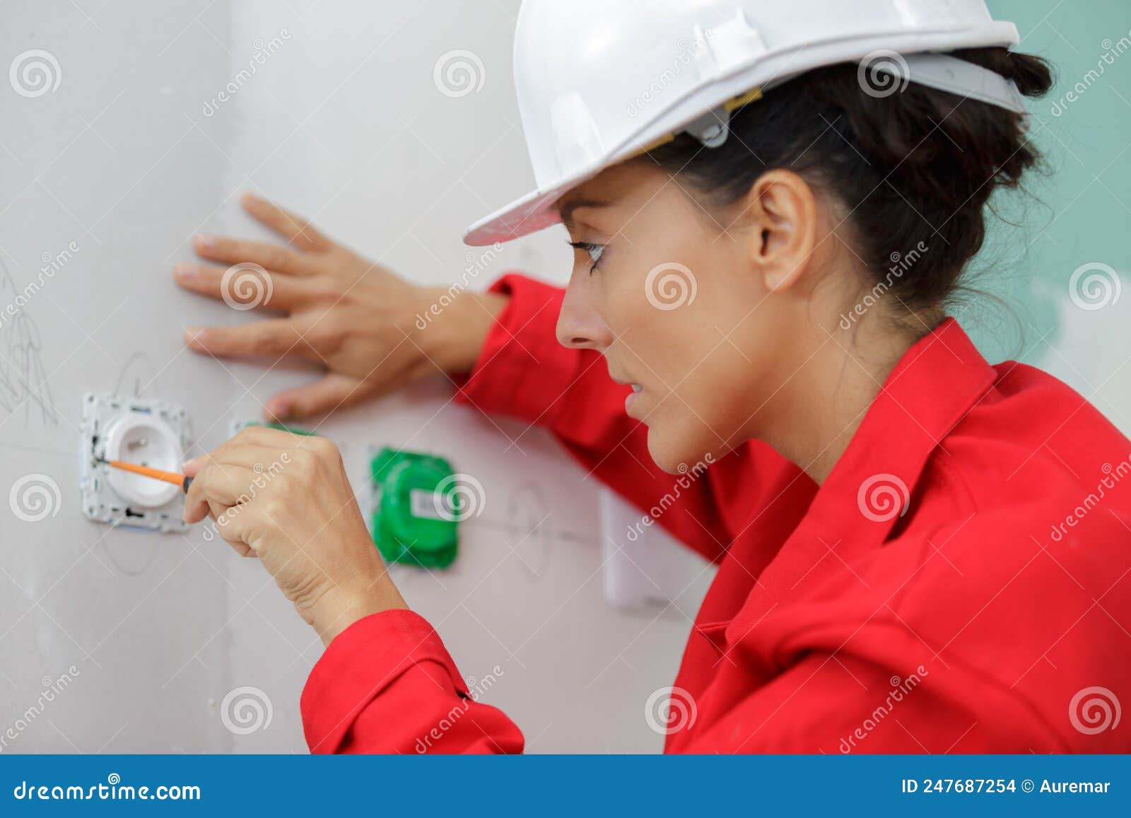 female electrician working on wall socket