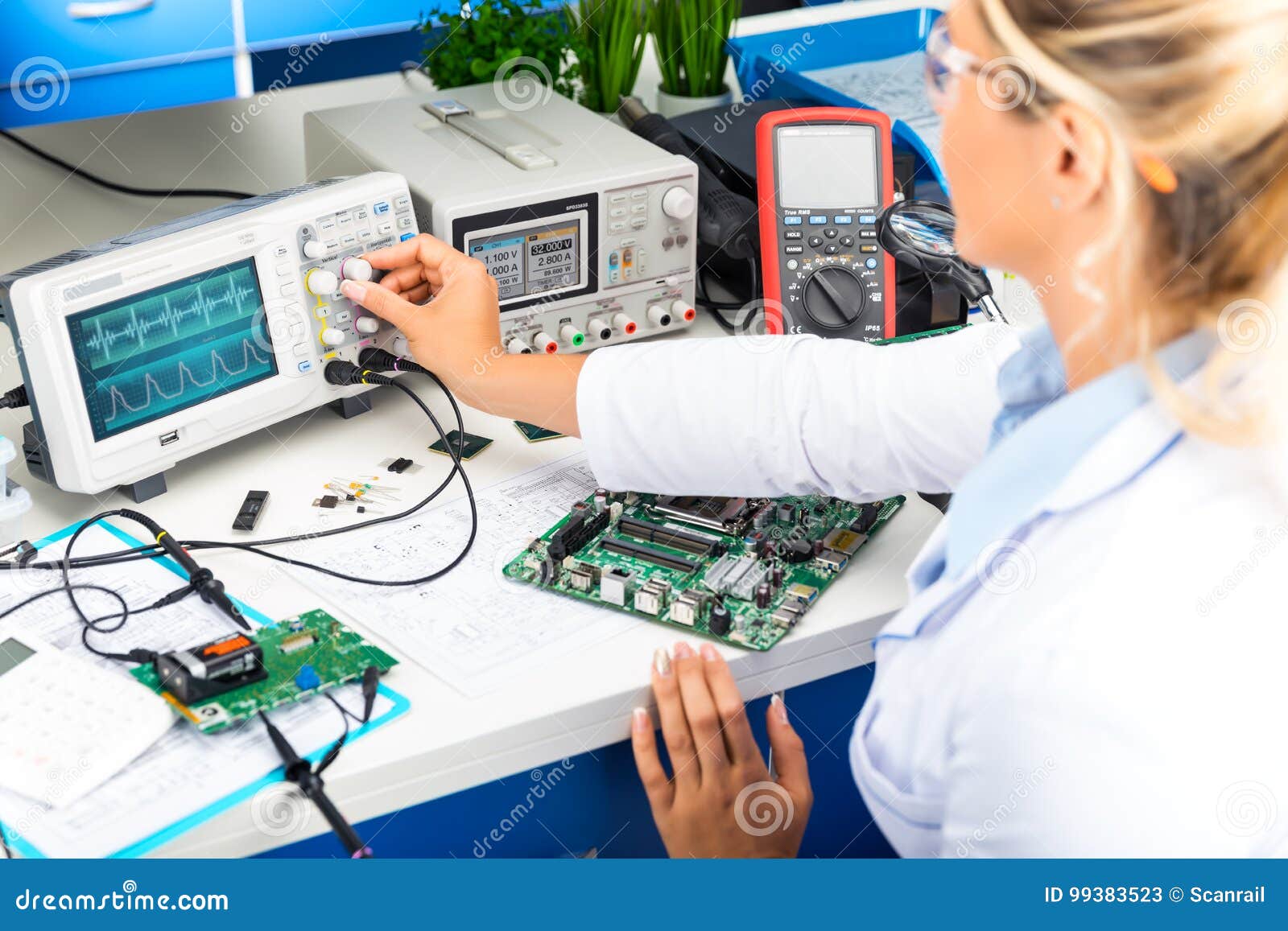 female electronic engineer using oscilloscope in laboratory