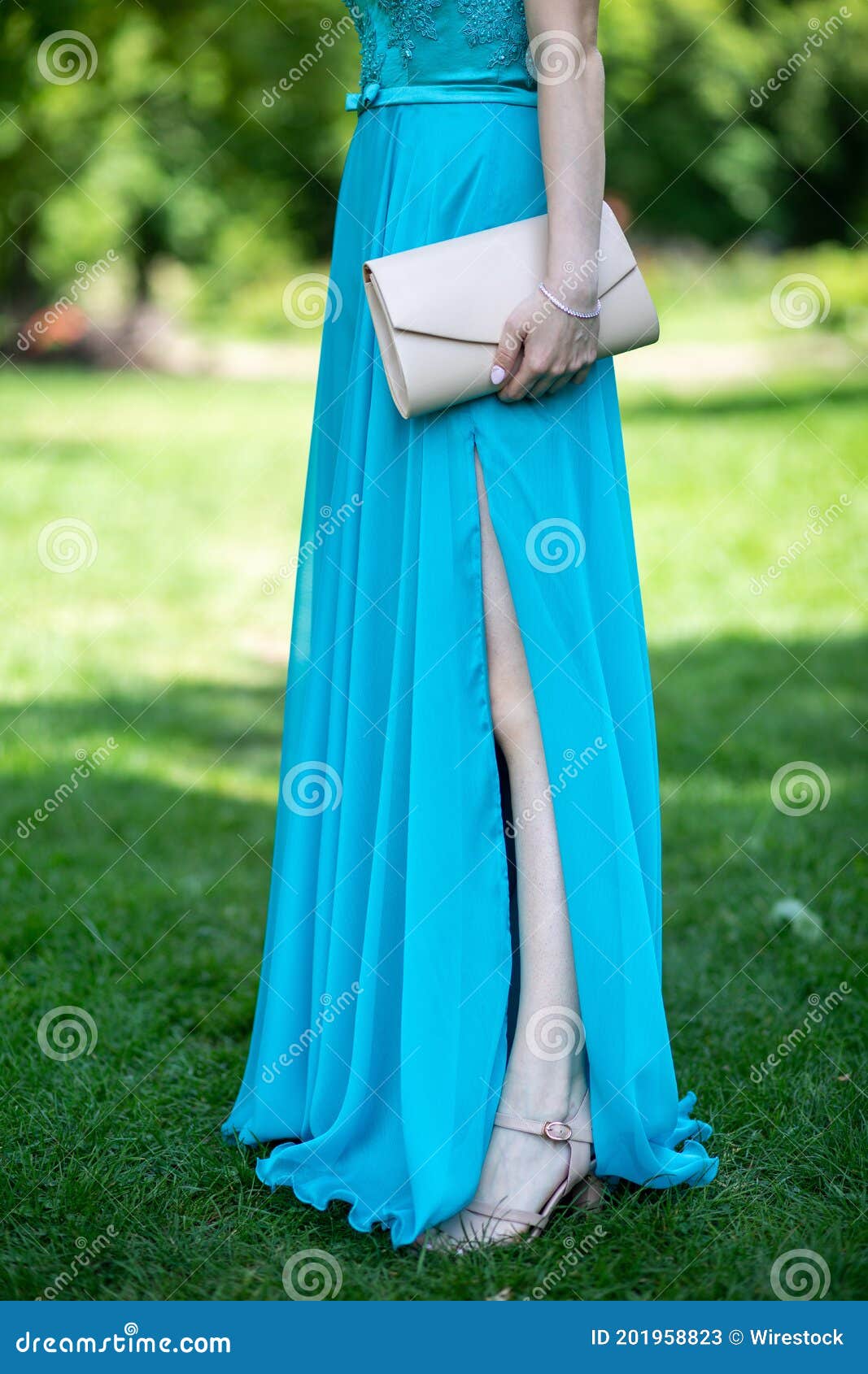 Female in an Elegant Long Turquoise Dress Holding a Cream Clutch Stock ...